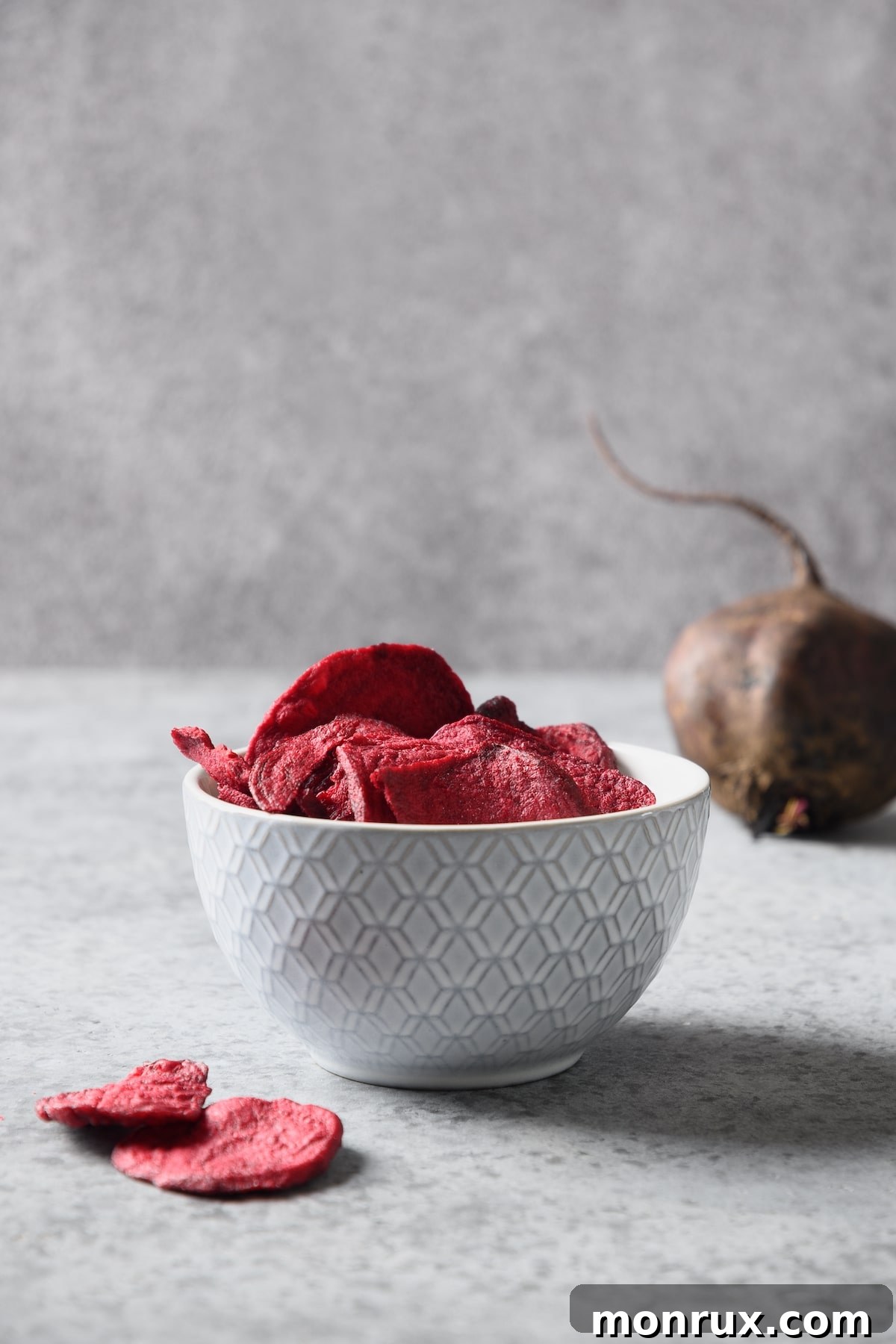A bowl brimming with vibrant dehydrated beetroot chips, ready for a healthy snack.