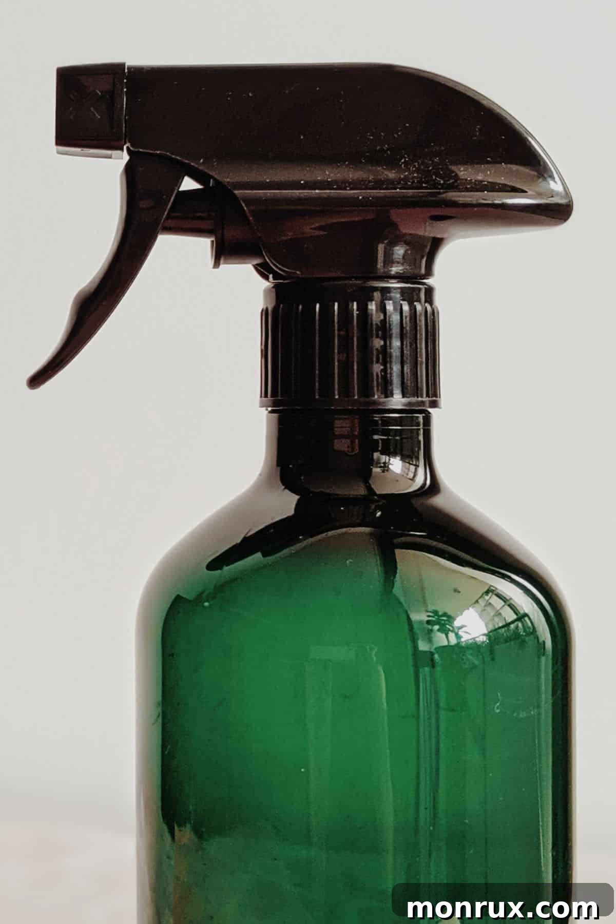 A green spray bottle, an essential tool for gently watering microgreen seeds.