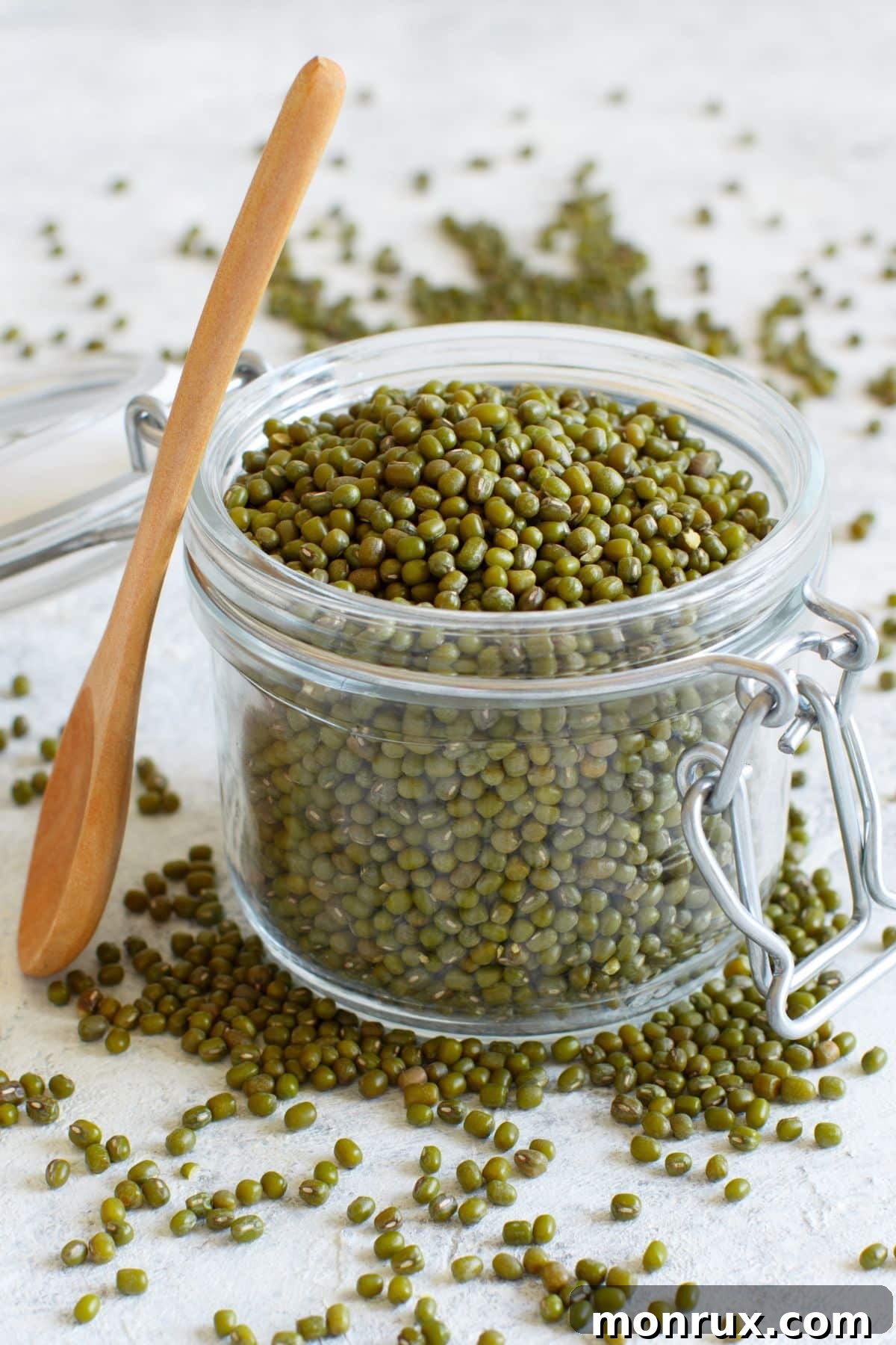 A glass jar filled with organic pea seeds, ready for planting.