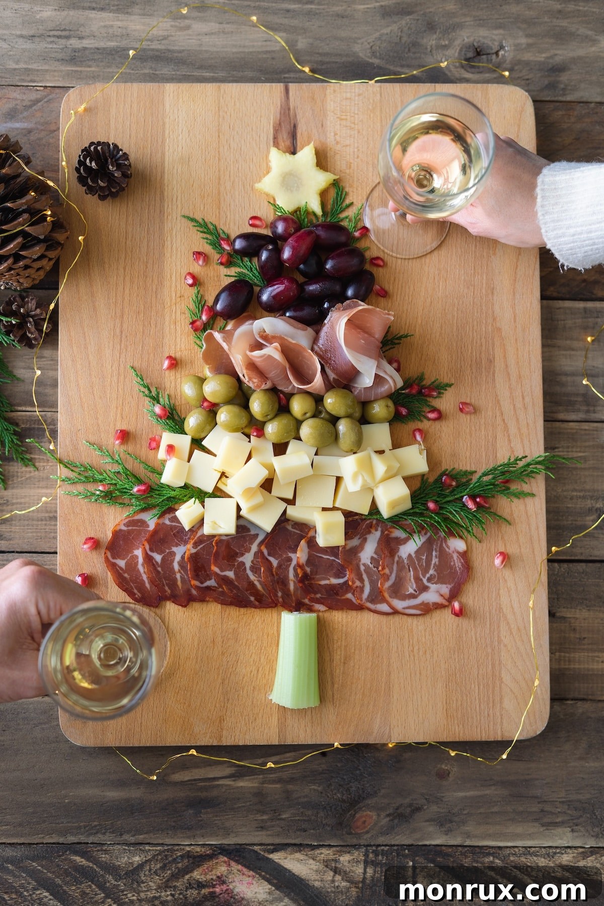 Guests enjoying wine with a Christmas tree shaped charcuterie board, highlighting a vibrant and appealing holiday spread.