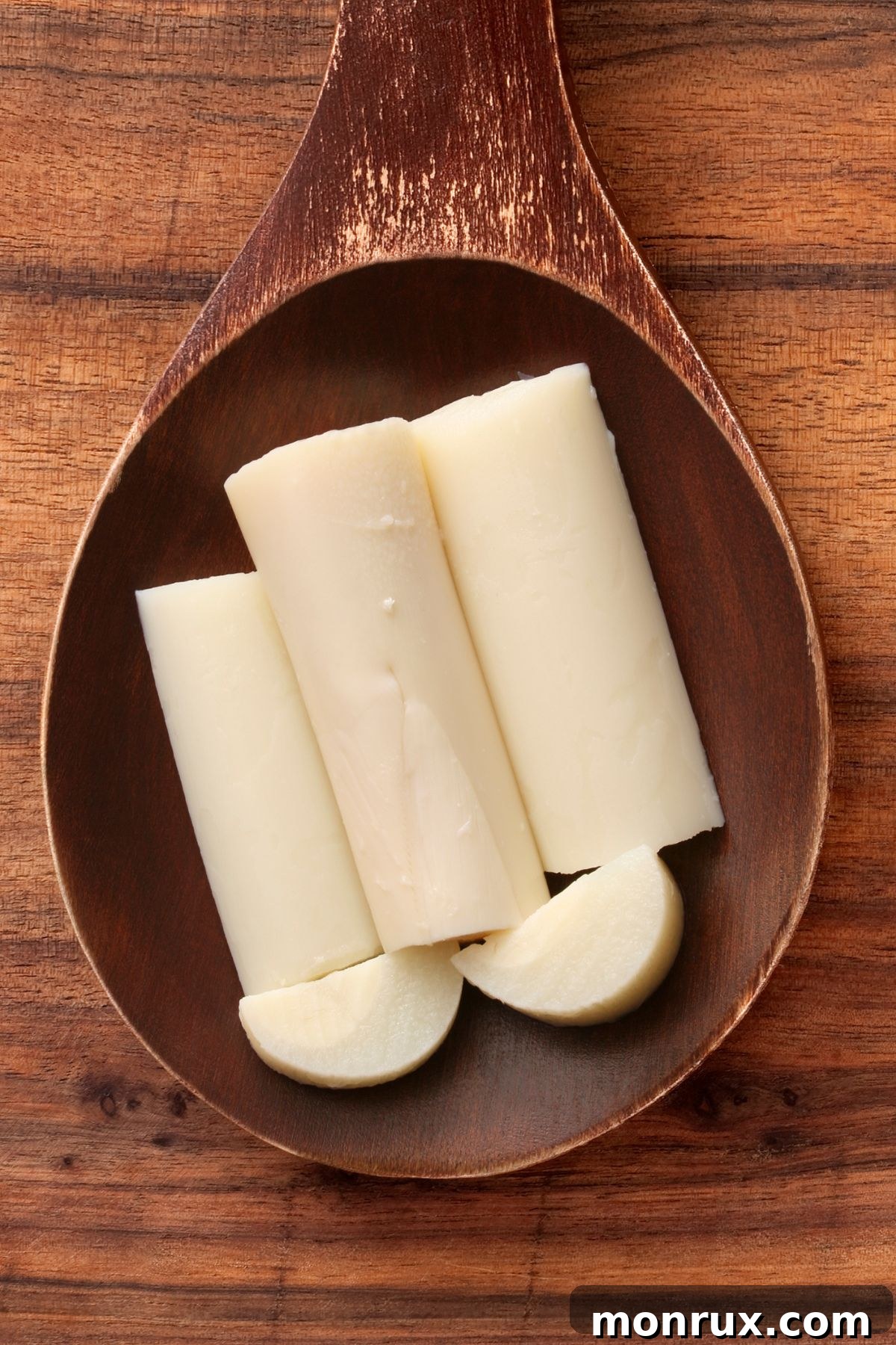 Delicate sliced hearts of palm presented elegantly in a rustic wooden dish, emphasizing their crisp white texture.