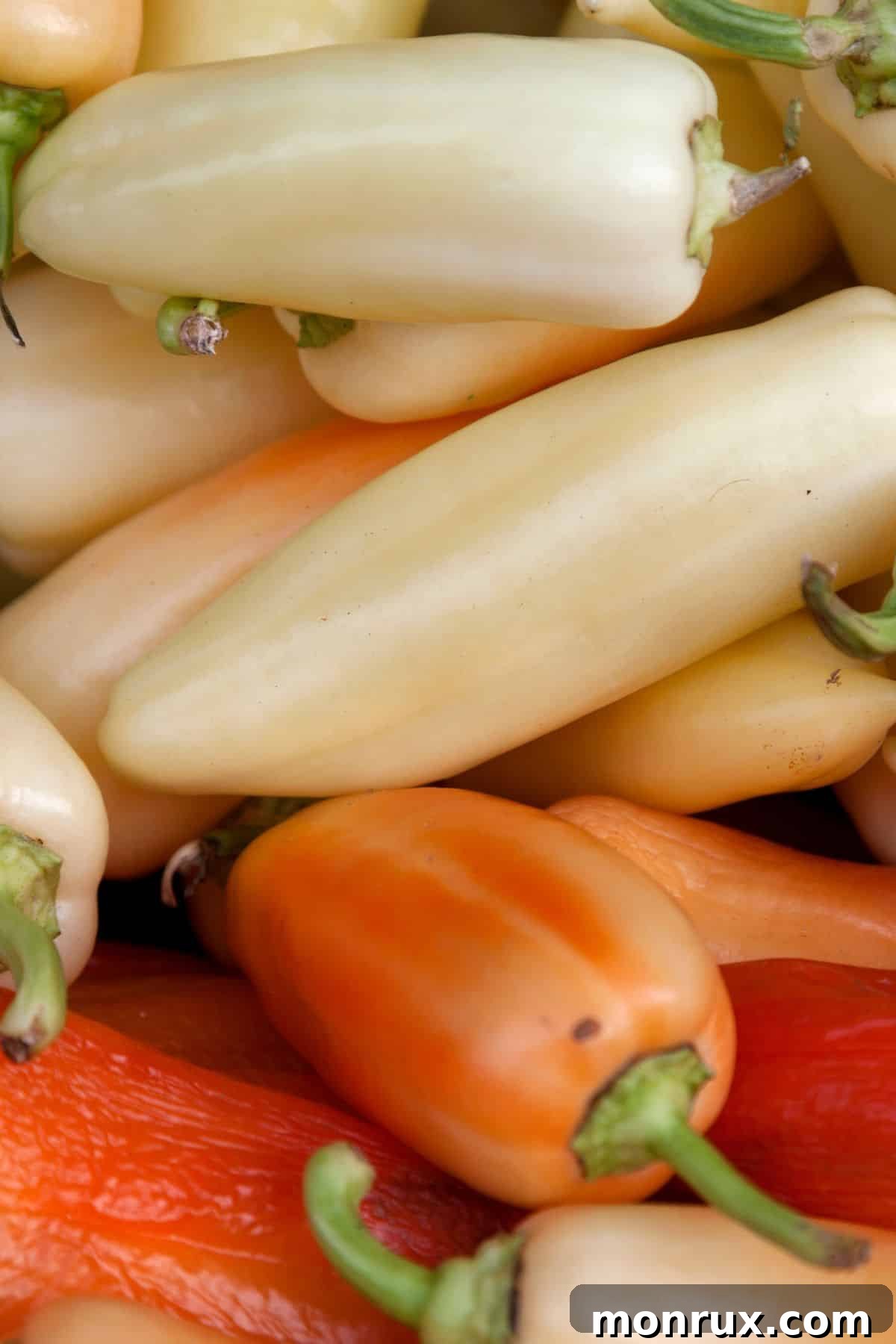 A vibrant close-up of several bright yellow Hungarian wax peppers, highlighting their smooth, waxy skin and elongated shape.