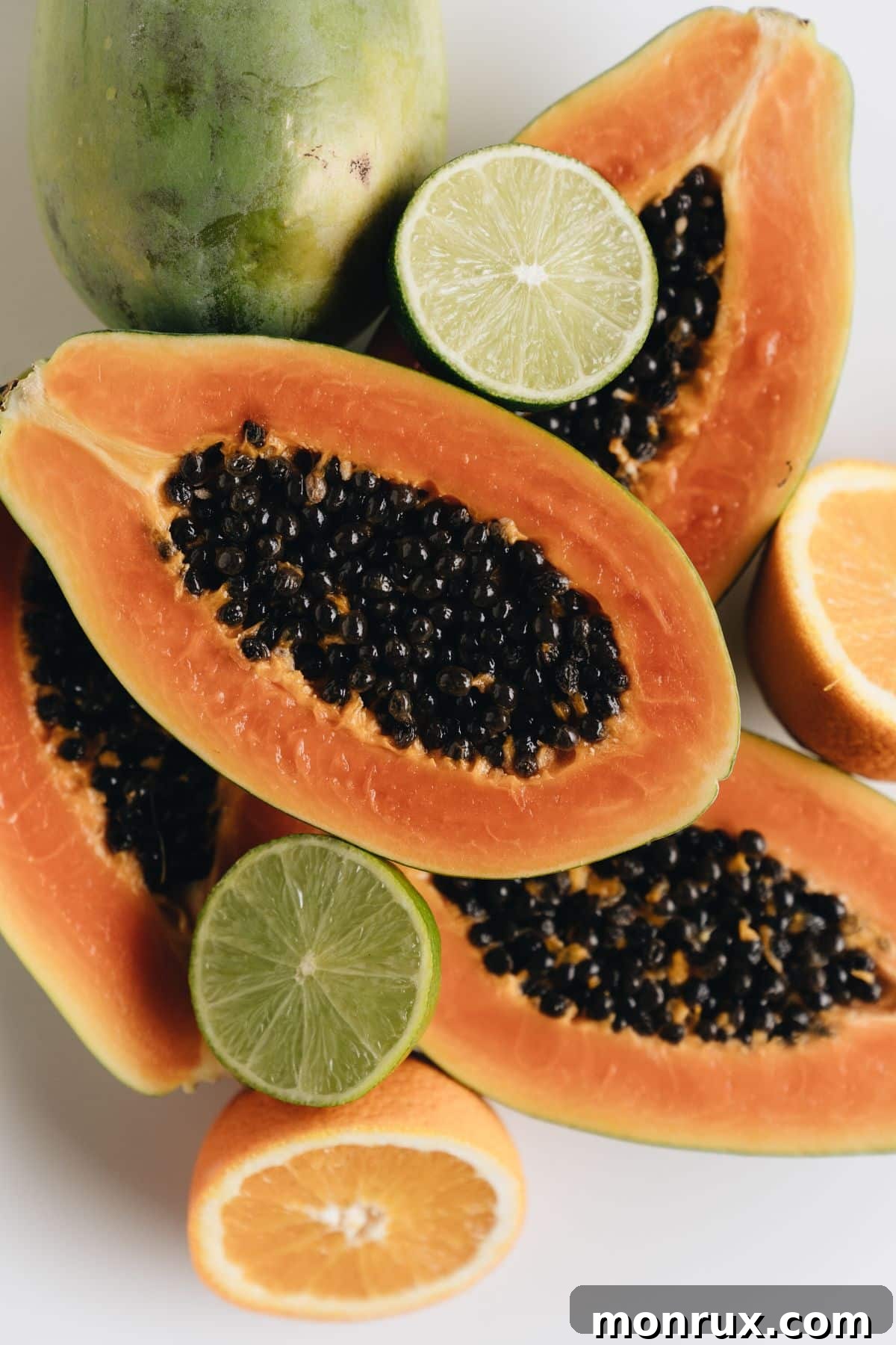 Artfully arranged halved papaya fruits alongside fresh citrus slices, highlighting the vibrant colors and natural beauty of the ingredients.