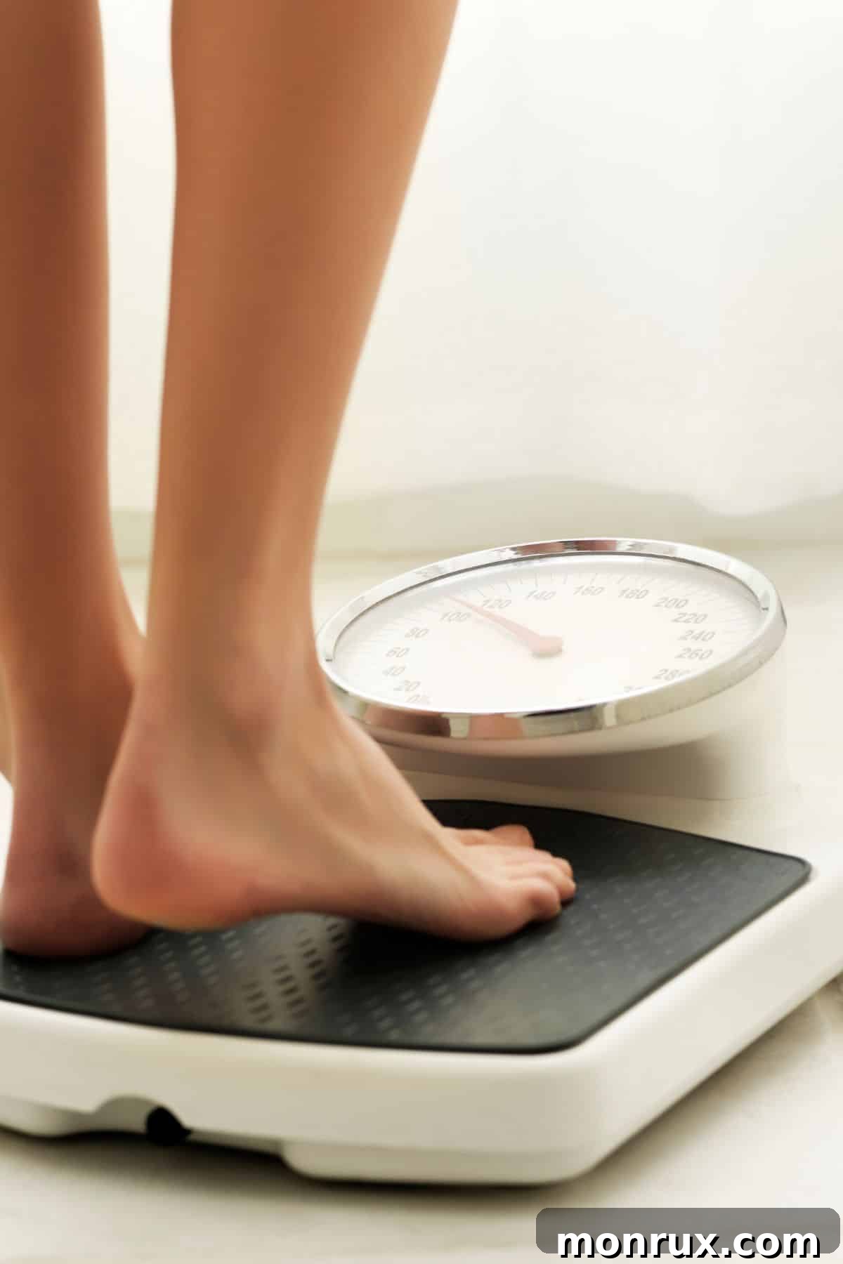 A woman standing on a scale, contemplating weight management. The image suggests the common struggle with weight when dealing with health conditions.