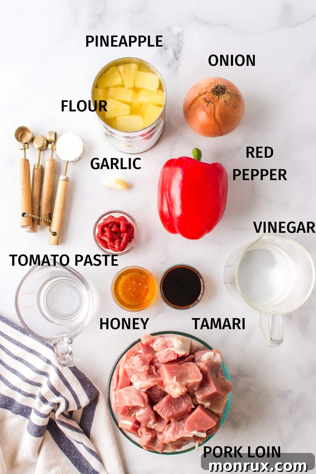 Ingredients to make sweet and sour pork on a white surface.