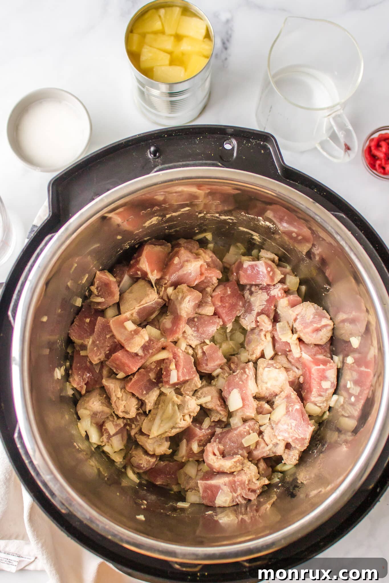 Pork cubes being browned in the liner of an Instant Pot.