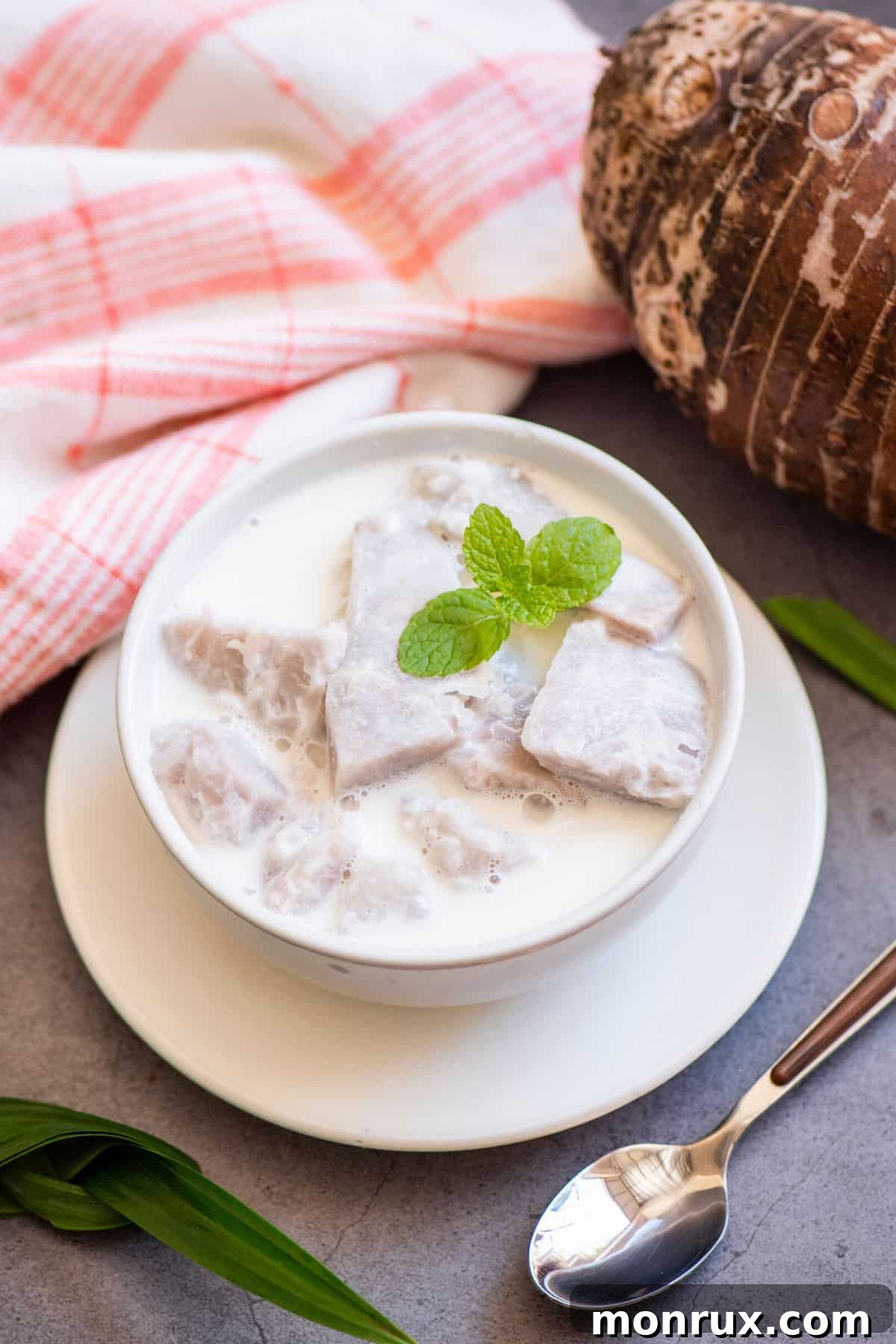 A small white bowl of taro milk topped with mint.