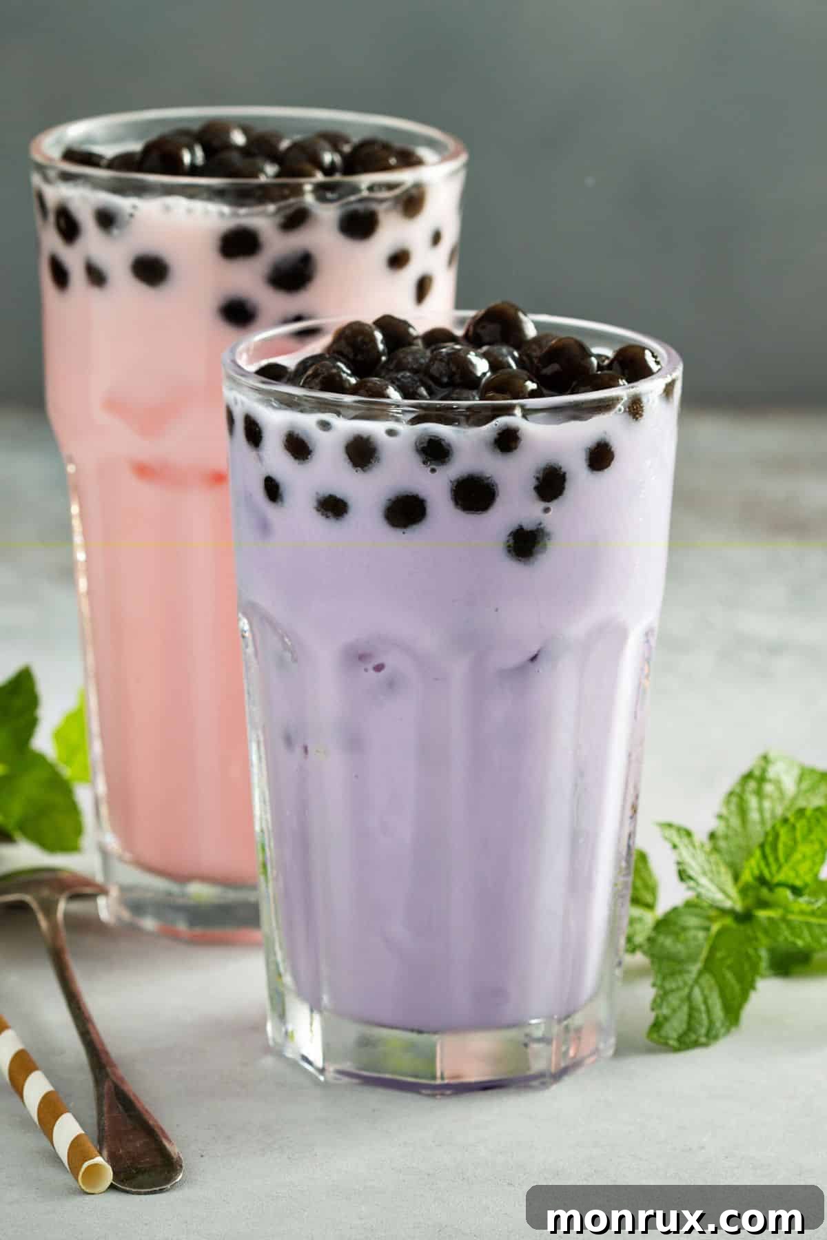 Two glasses of taro milk with boba pearls.