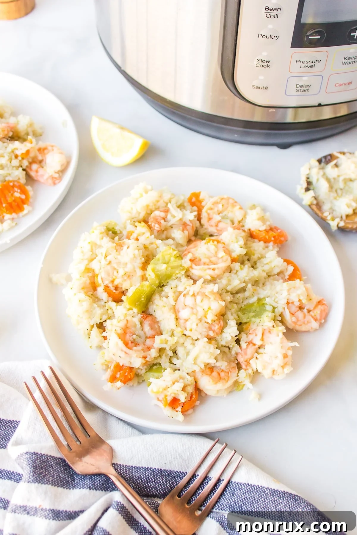Instant Pot Rice and Shrimp on a white dinner plate, garnished with fresh herbs.