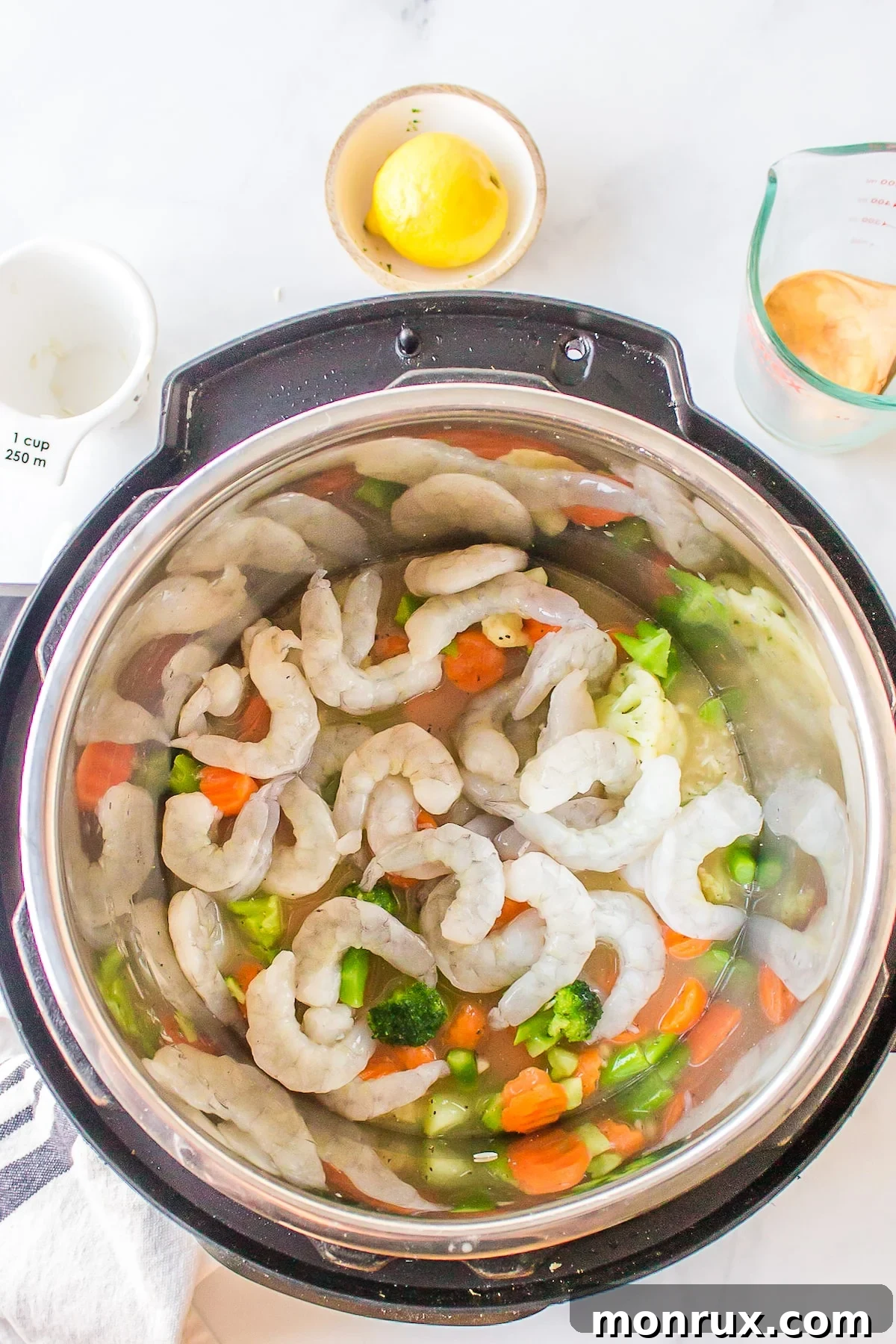 Frozen shrimp carefully placed on top of the rice and vegetable mixture in the Instant Pot.