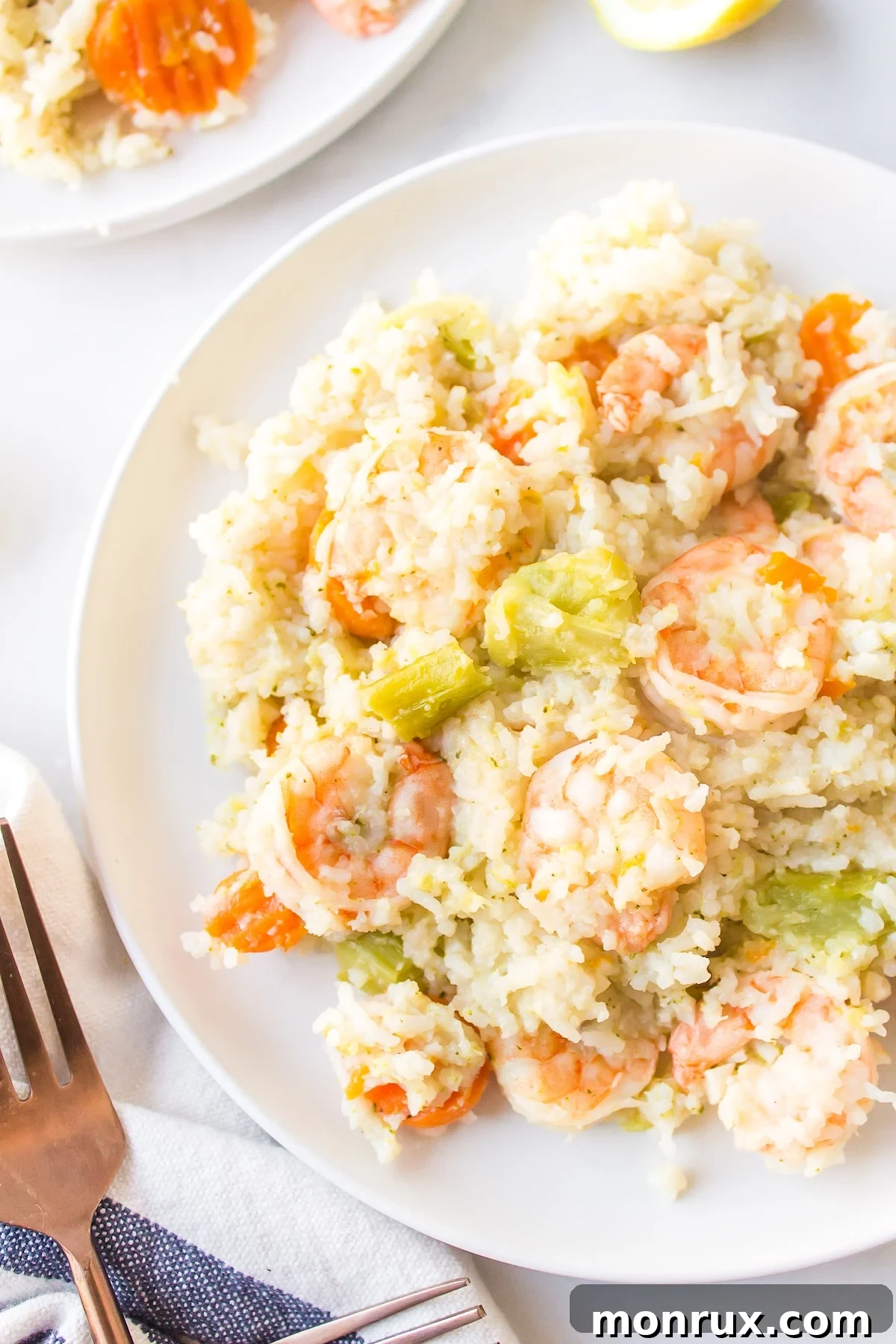 A serving of Instant Pot shrimp and rice garnished with fresh parsley on a white plate.