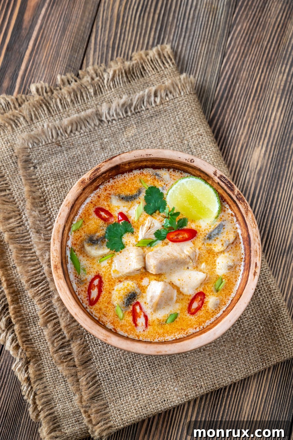 A comforting bowl of Tom Kha Kai soup, featuring chicken and mushrooms in a creamy coconut broth.