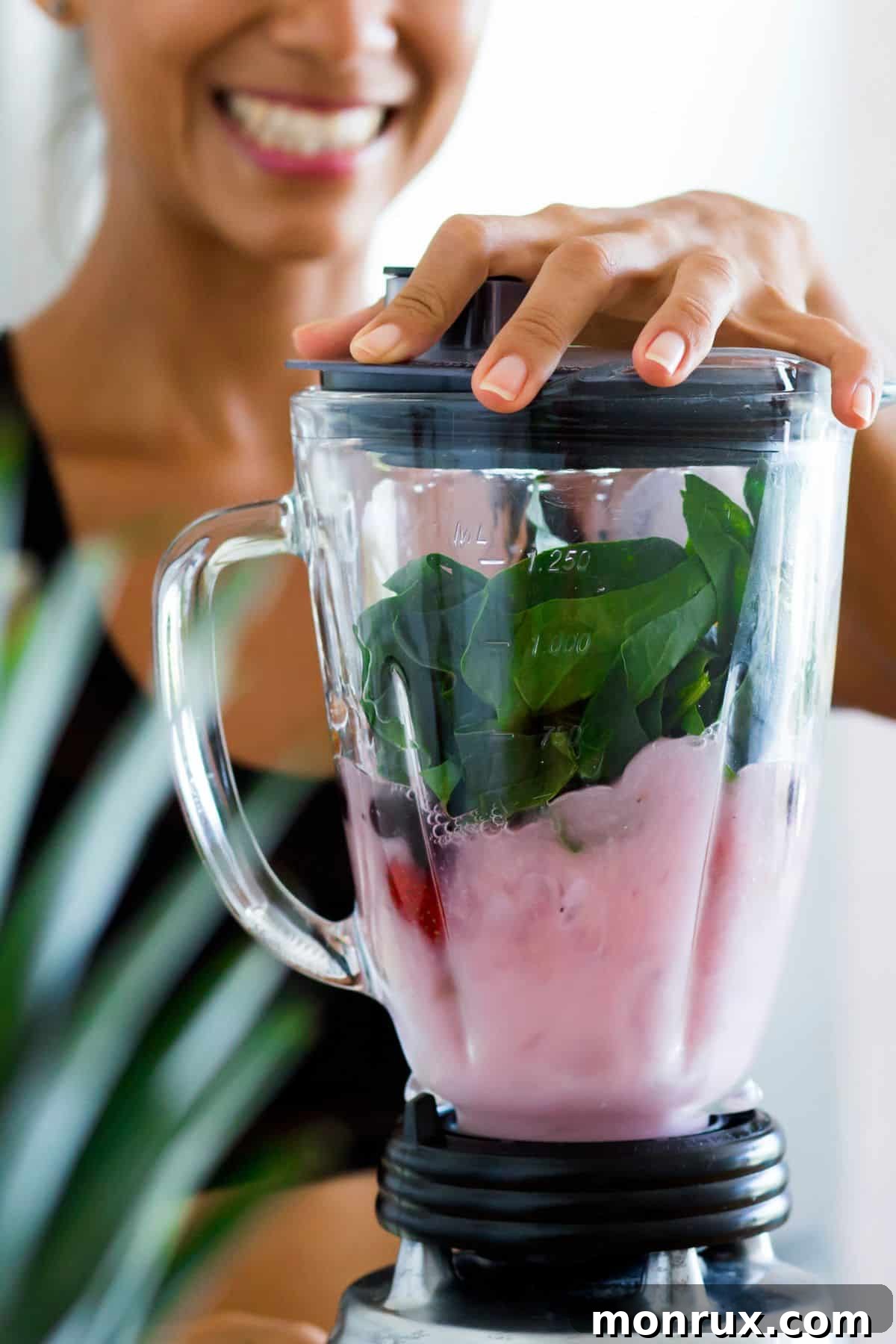 a woman using a blender in a modern kitchen, preparing a healthy smoothie.