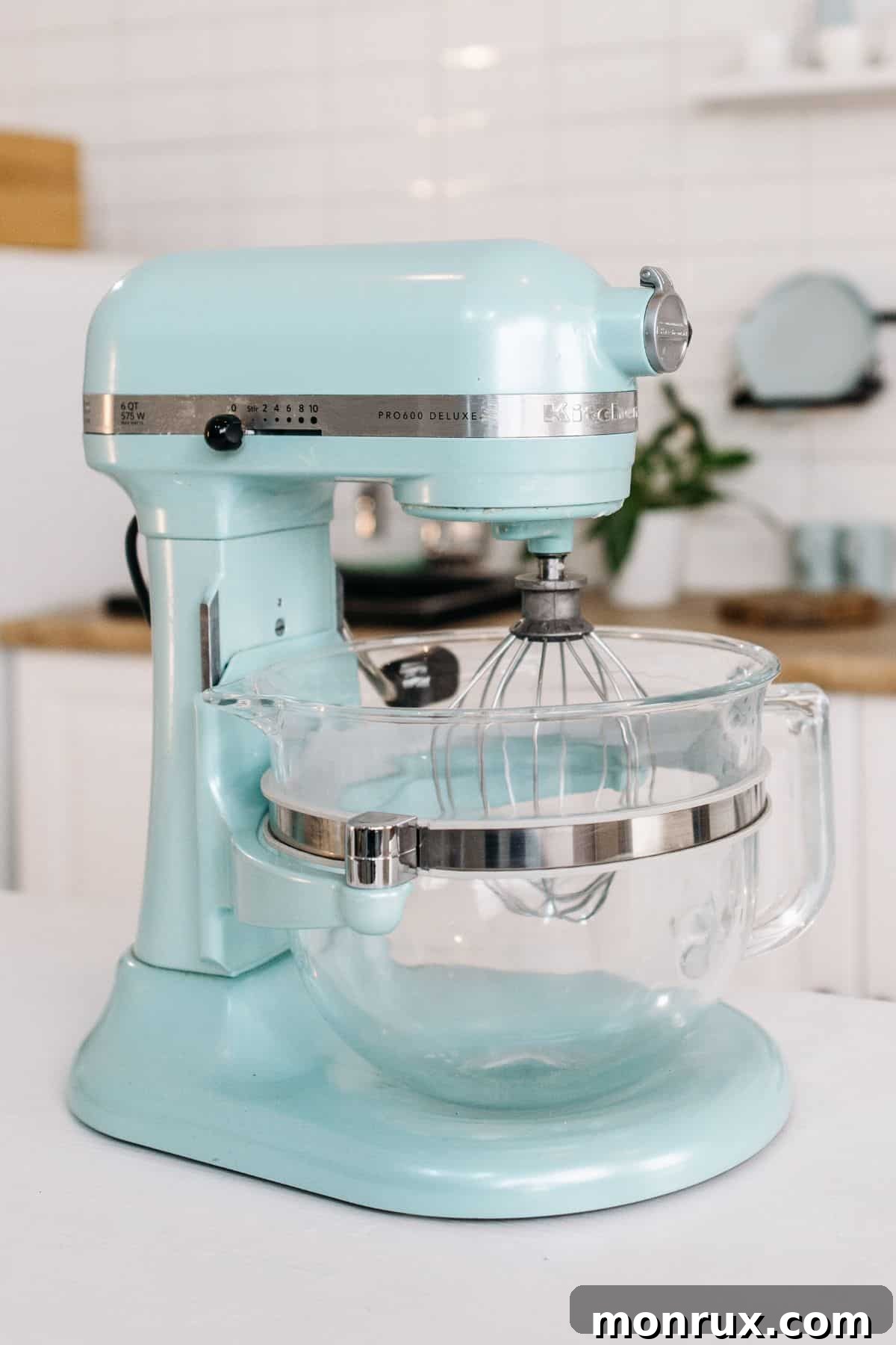 a stylish blue stand mixer on a clean kitchen counter, ready for use.