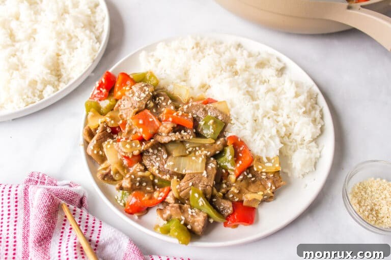copycat P.F. Chang's Pepper Steak on a white plate with rice.