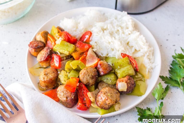 air fryer sausage and peppers on a white plate with rice.