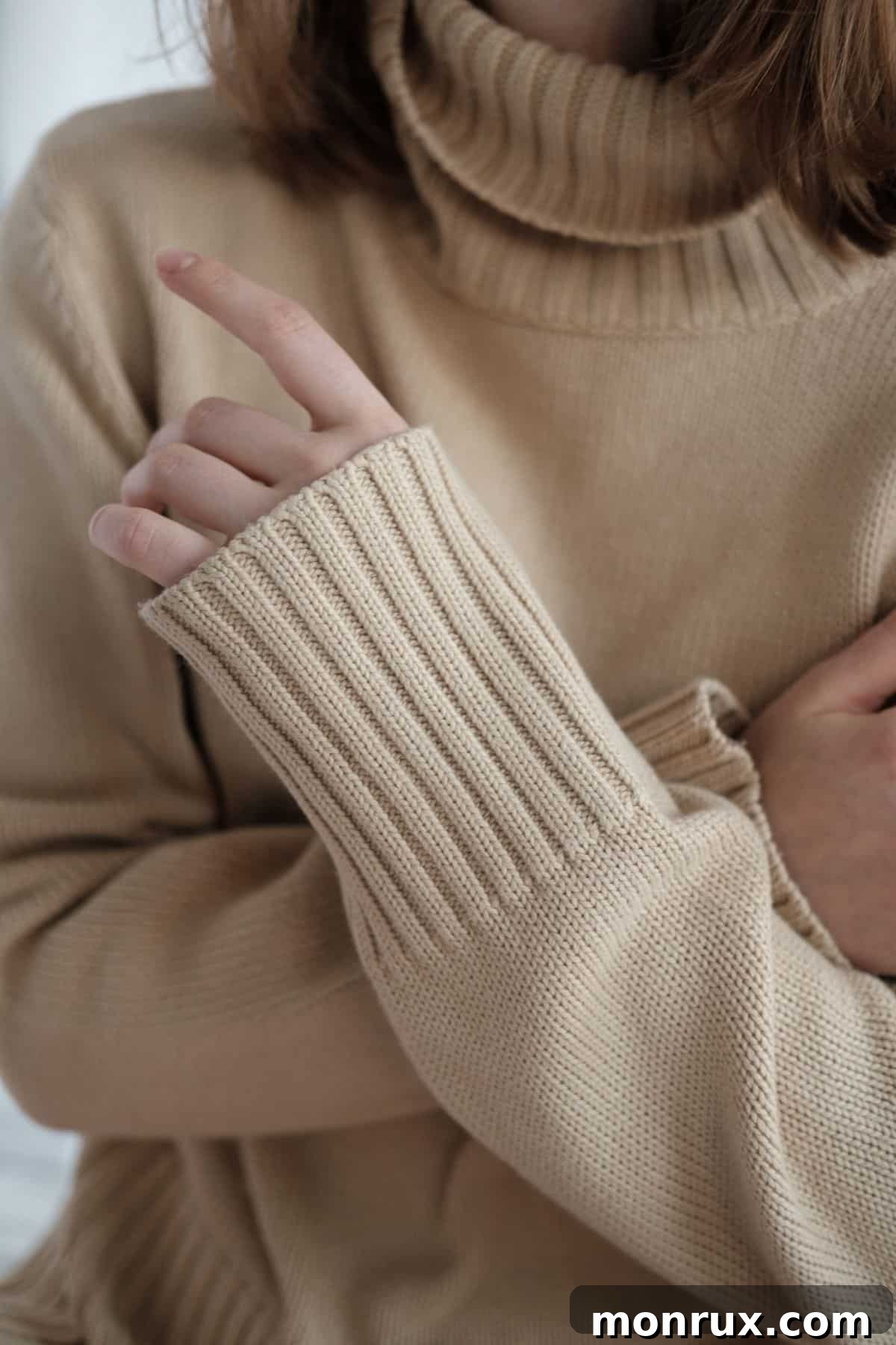 A woman covers her chest with her arms, illustrating breast tenderness.