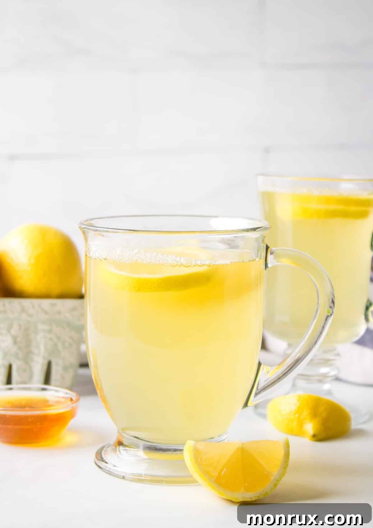 Honey lemon tea served in clear mug with handle.