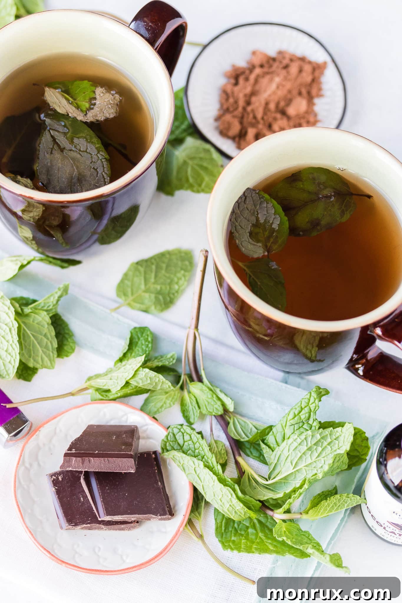 Two mugs of comforting chocolate mint tea with fresh mint sprigs