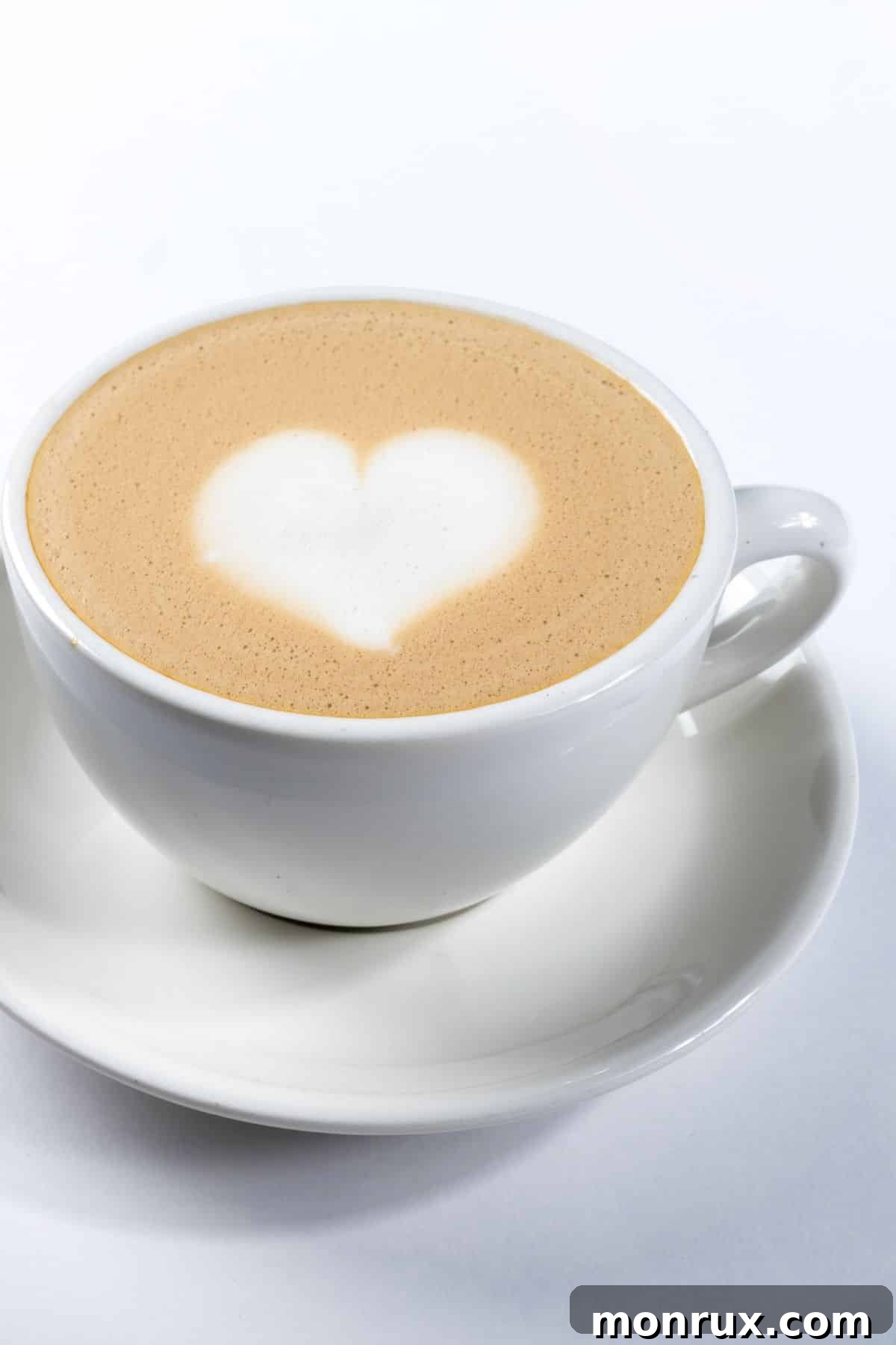 A delicious dairy-free latte in a mug, adorned with a delicate heart design in the froth.