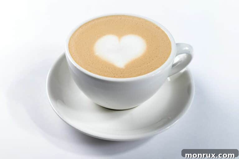 A delicious dairy-free latte in a mug, adorned with a delicate heart design in the froth.