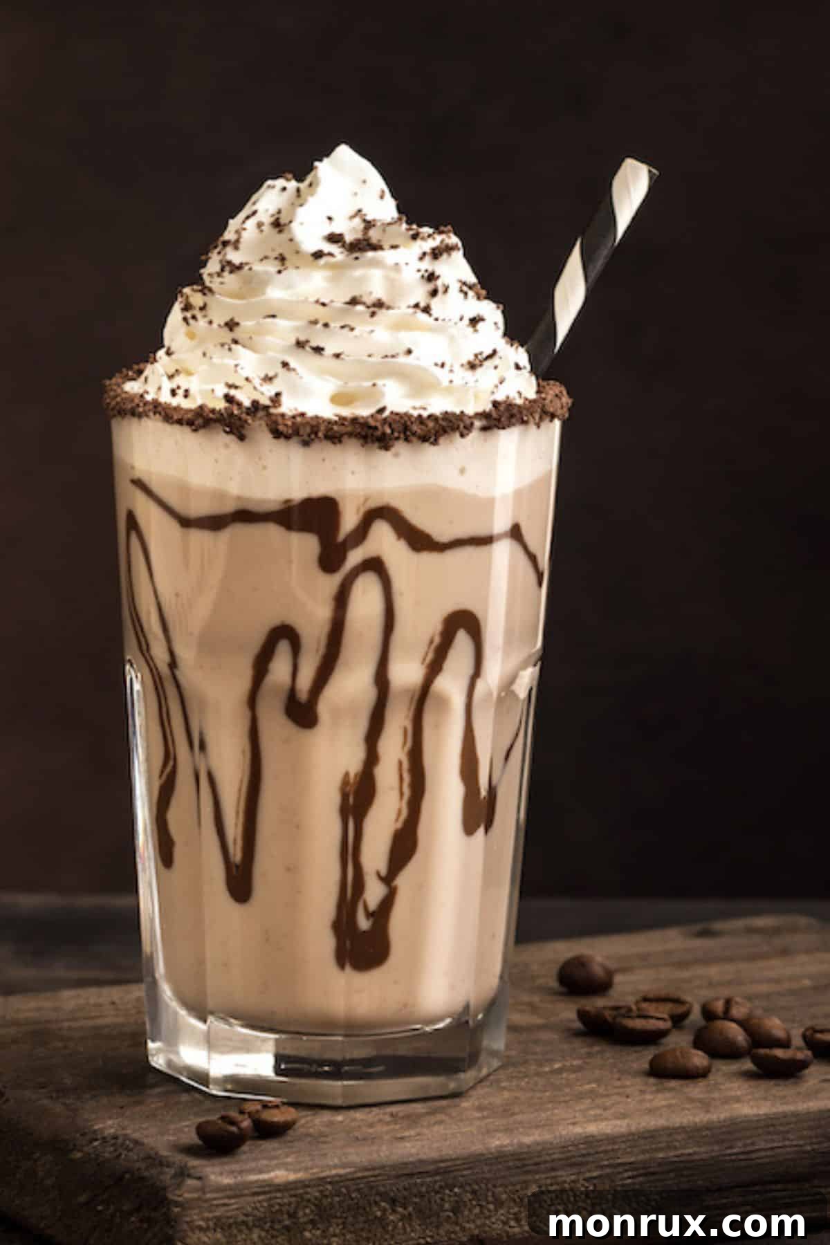 A beautifully presented dairy-free iced mocha, generously topped with fluffy coconut whipped cream and a drizzle of rich chocolate syrup, served in a clear glass.