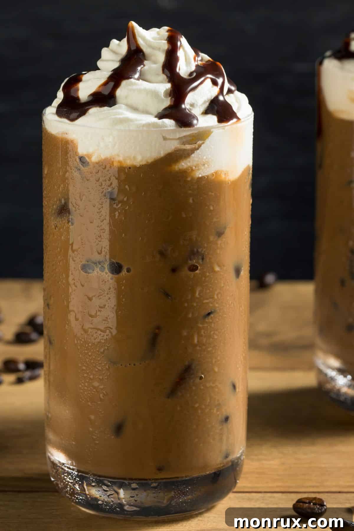 A close-up shot of a dairy-free iced mocha adorned with a generous dollop of whipped cream and a delicate swirl of chocolate syrup, ready to be enjoyed.