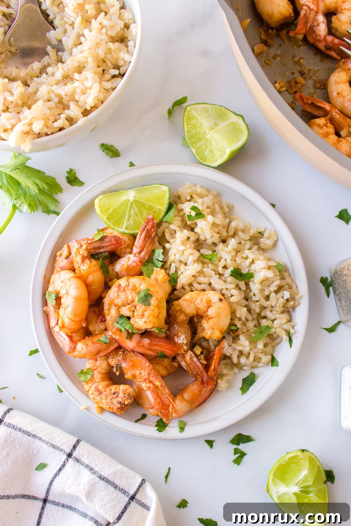 A vibrant plate of homemade Costco copycat cilantro lime shrimp, served alongside fluffy white rice, garnished with fresh cilantro and lime wedges.