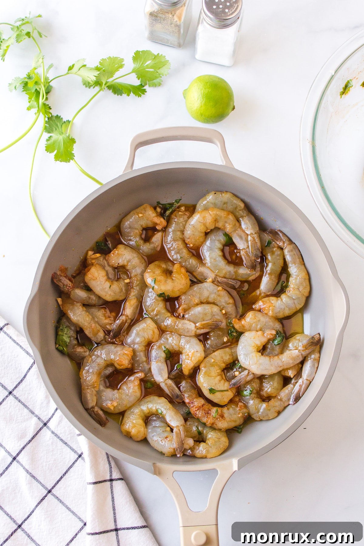 Shrimp cooking in a hot skillet, turning pink and slightly browned.