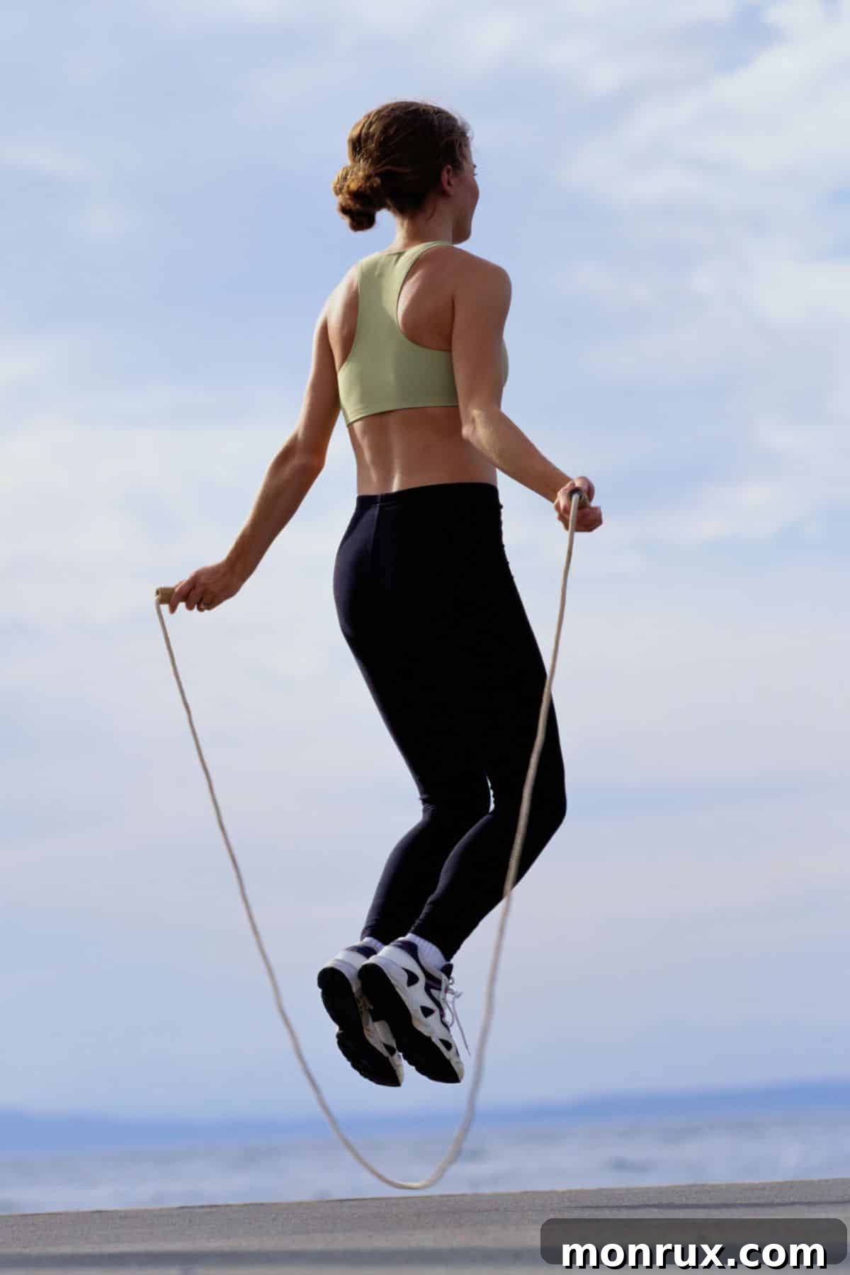 A dynamic image of a woman enthusiastically jumping rope, symbolizing increased energy and an active lifestyle, often associated with healthy hydration.