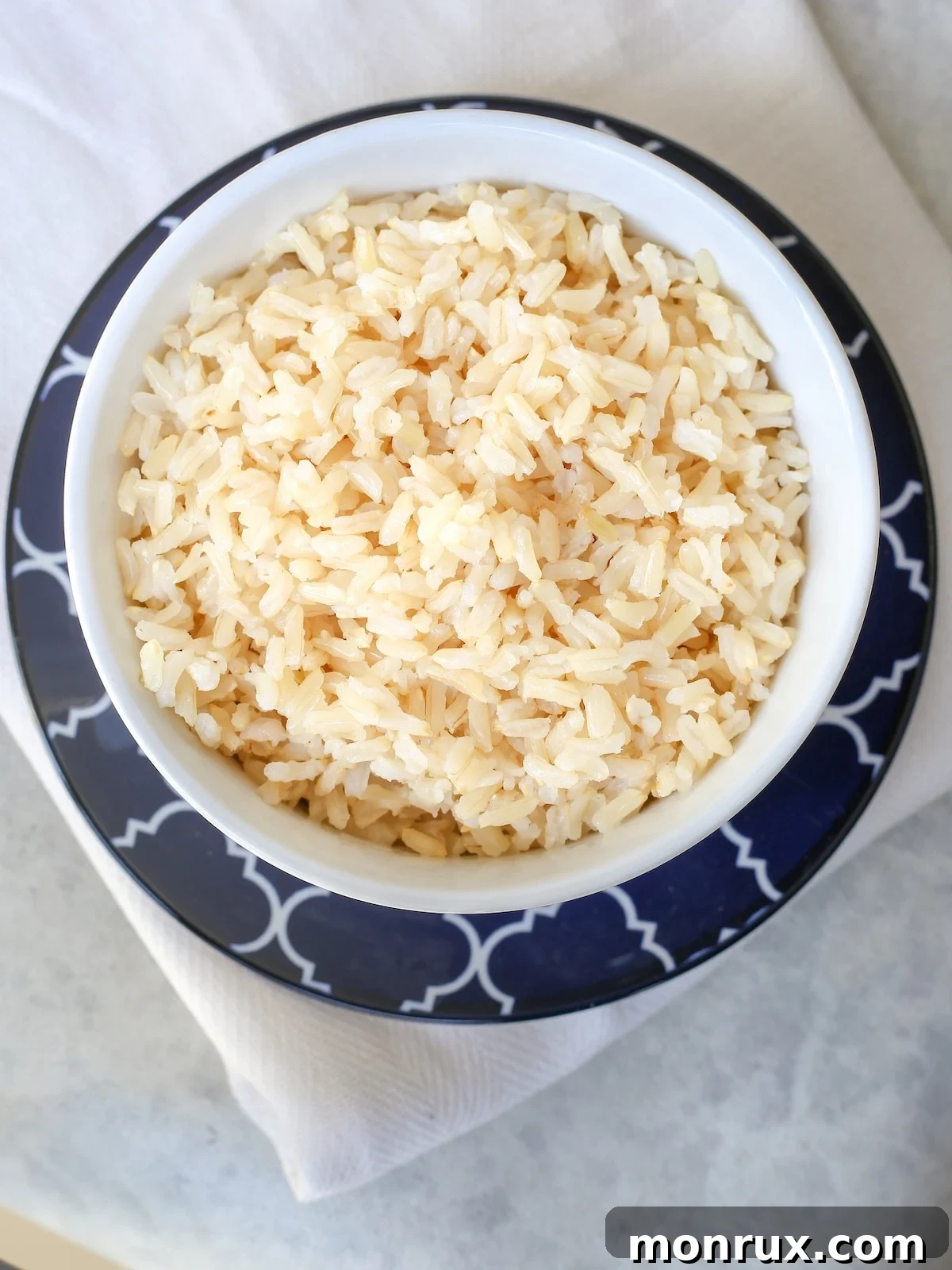 A beautifully presented bowl of fluffy bone broth rice, garnished lightly and ready to be served as a nourishing side dish.