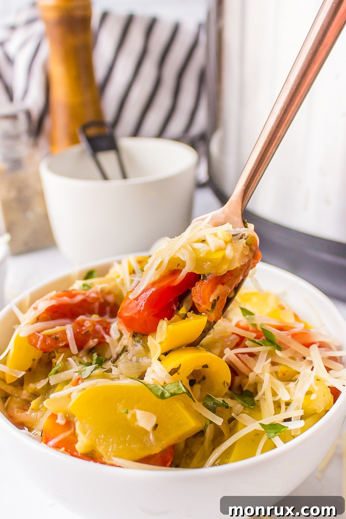 A fork lifts a savory bite of Instant Pot yellow squash and tomatoes.