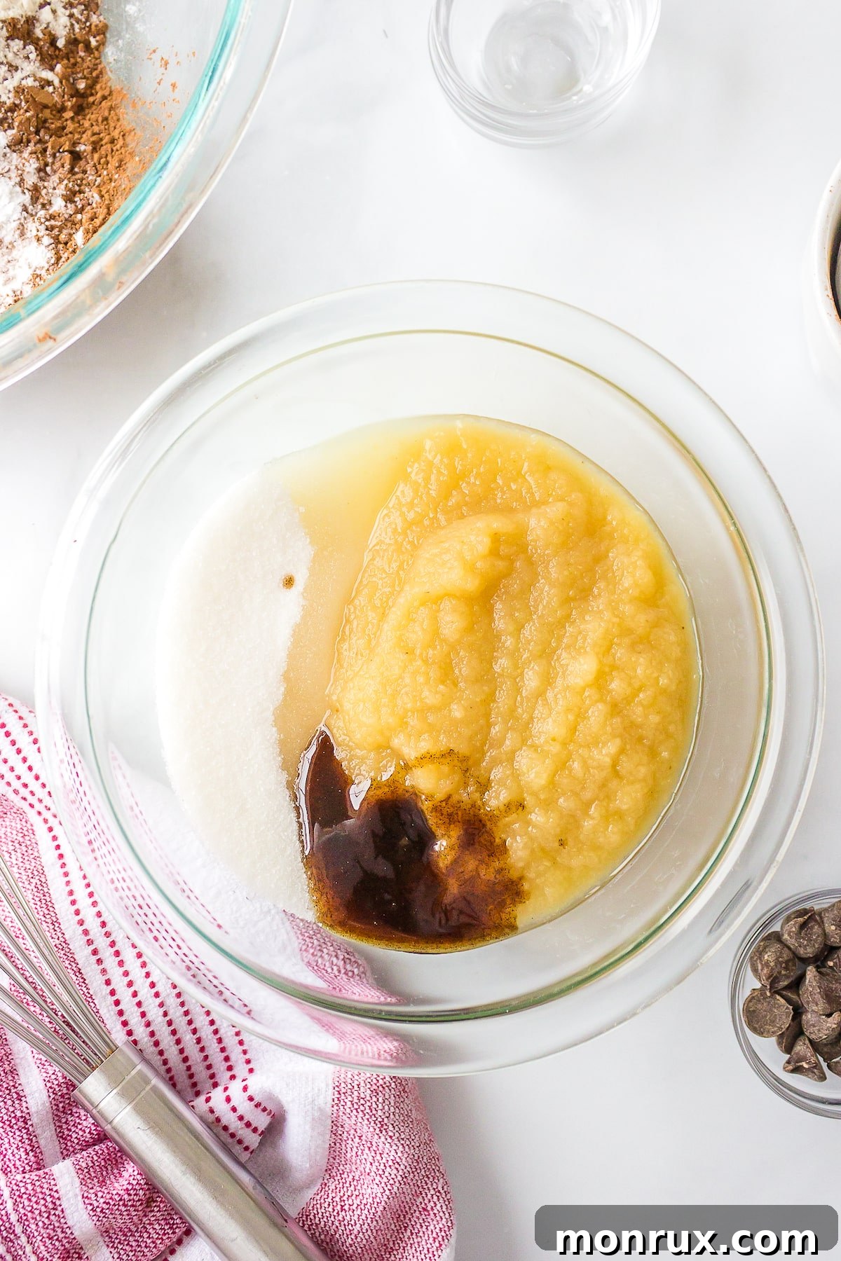 Bowl containing wet ingredients for dairy-free brownies, including applesauce and oil, ready to be mixed for the batter.