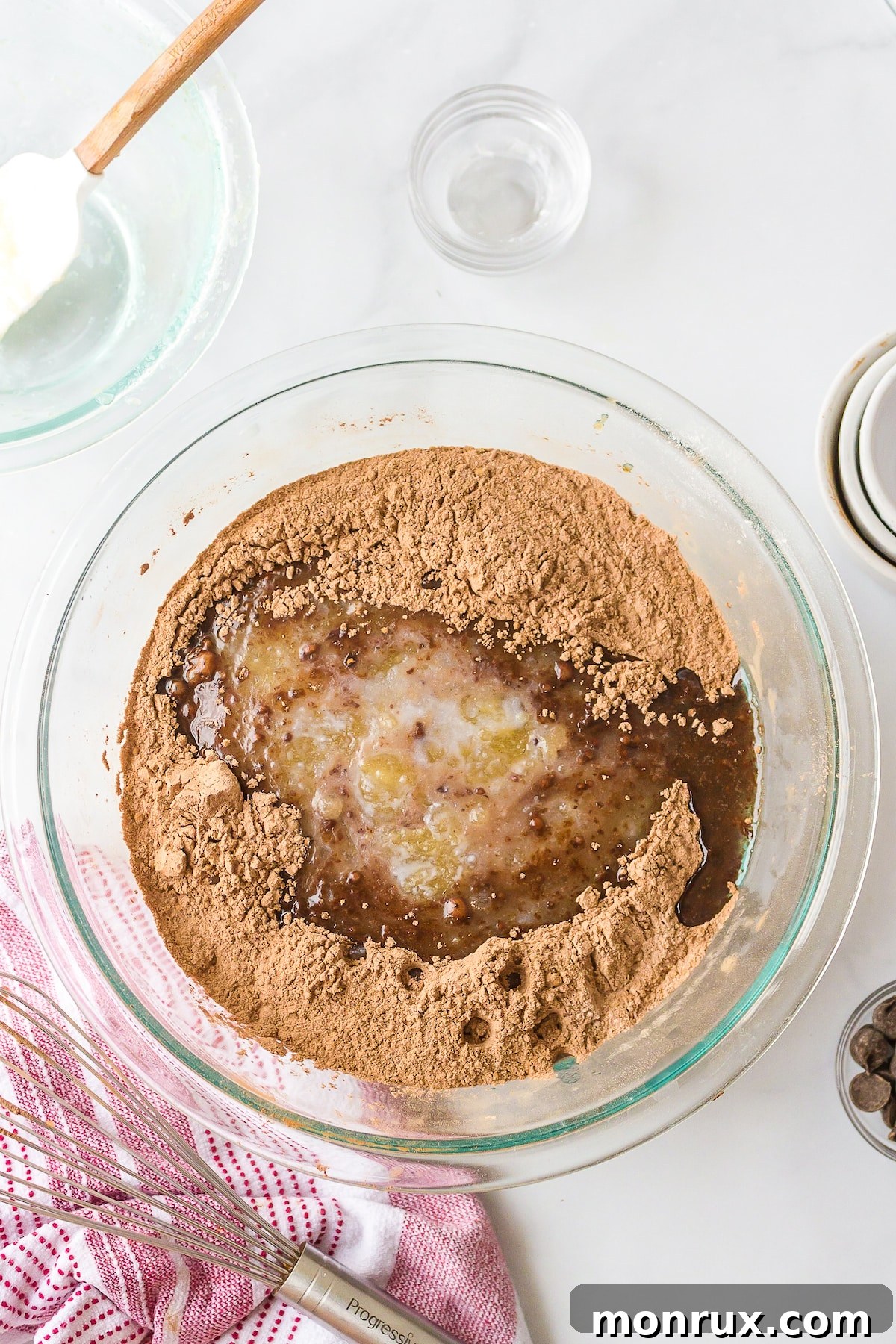 Mixing bowl with both wet and dry ingredients for dairy-free brownie batter, showing the rich cocoa color and smooth consistency before final mixing.