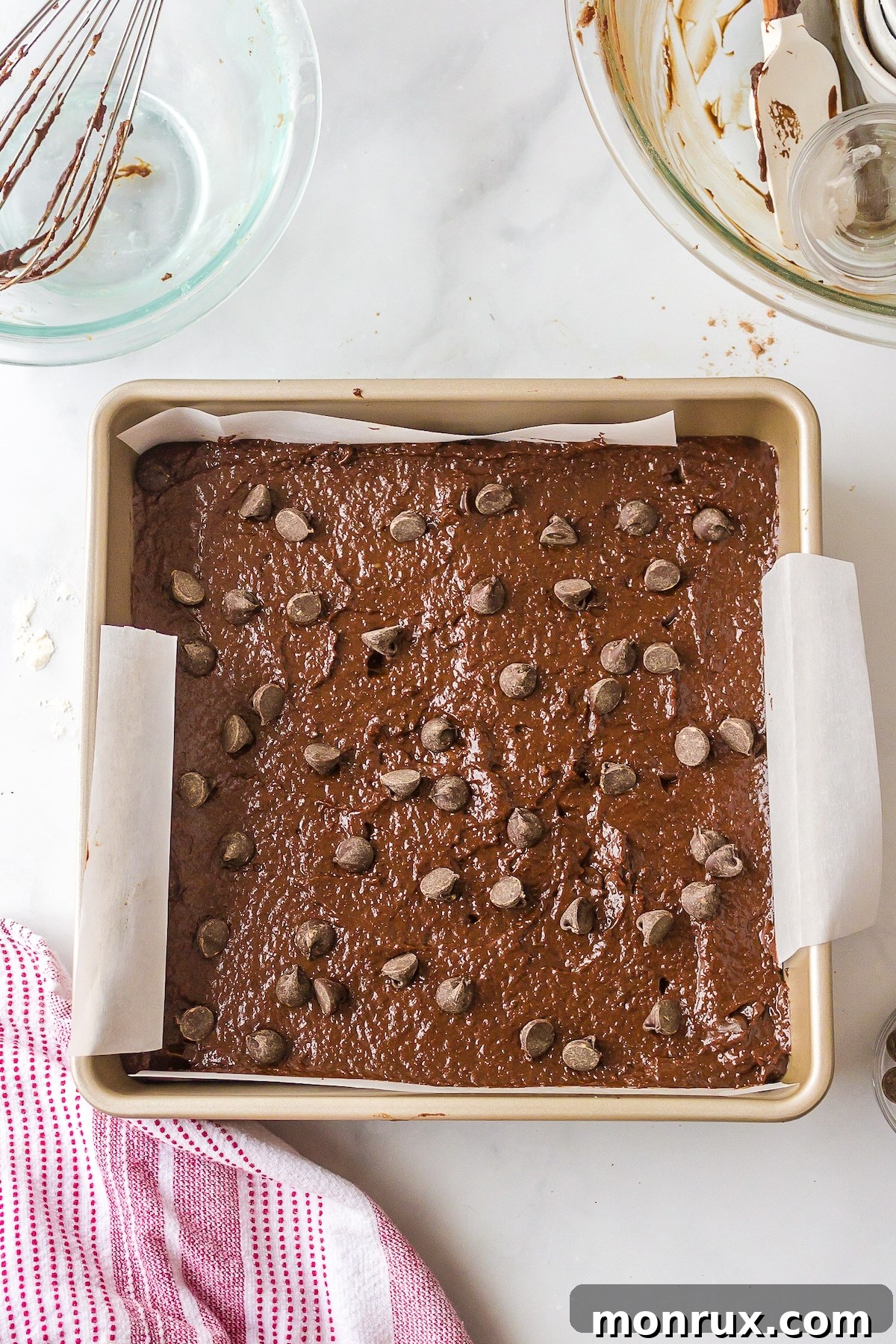 Perfectly baked dairy-free brownies in a square baking pan, showcasing the golden-brown edges and rich chocolate center before being sliced.