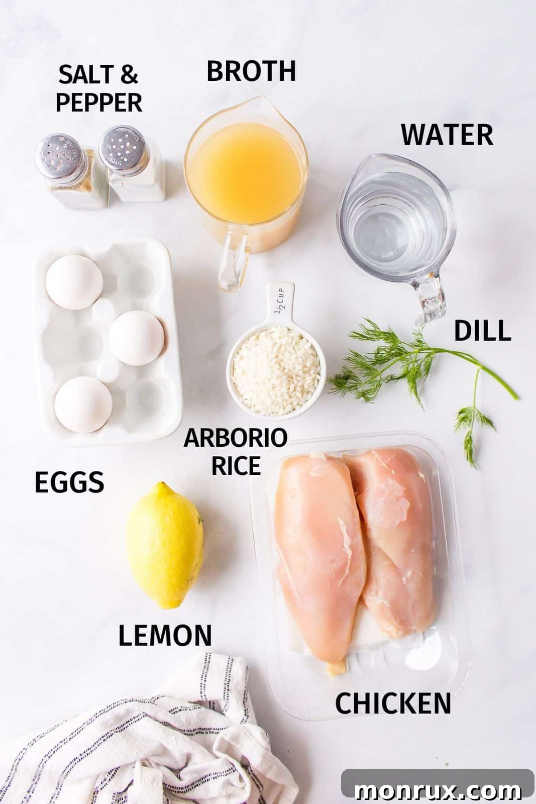 A selection of fresh ingredients for avgolemono soup, including chicken, rice, lemons, and eggs.