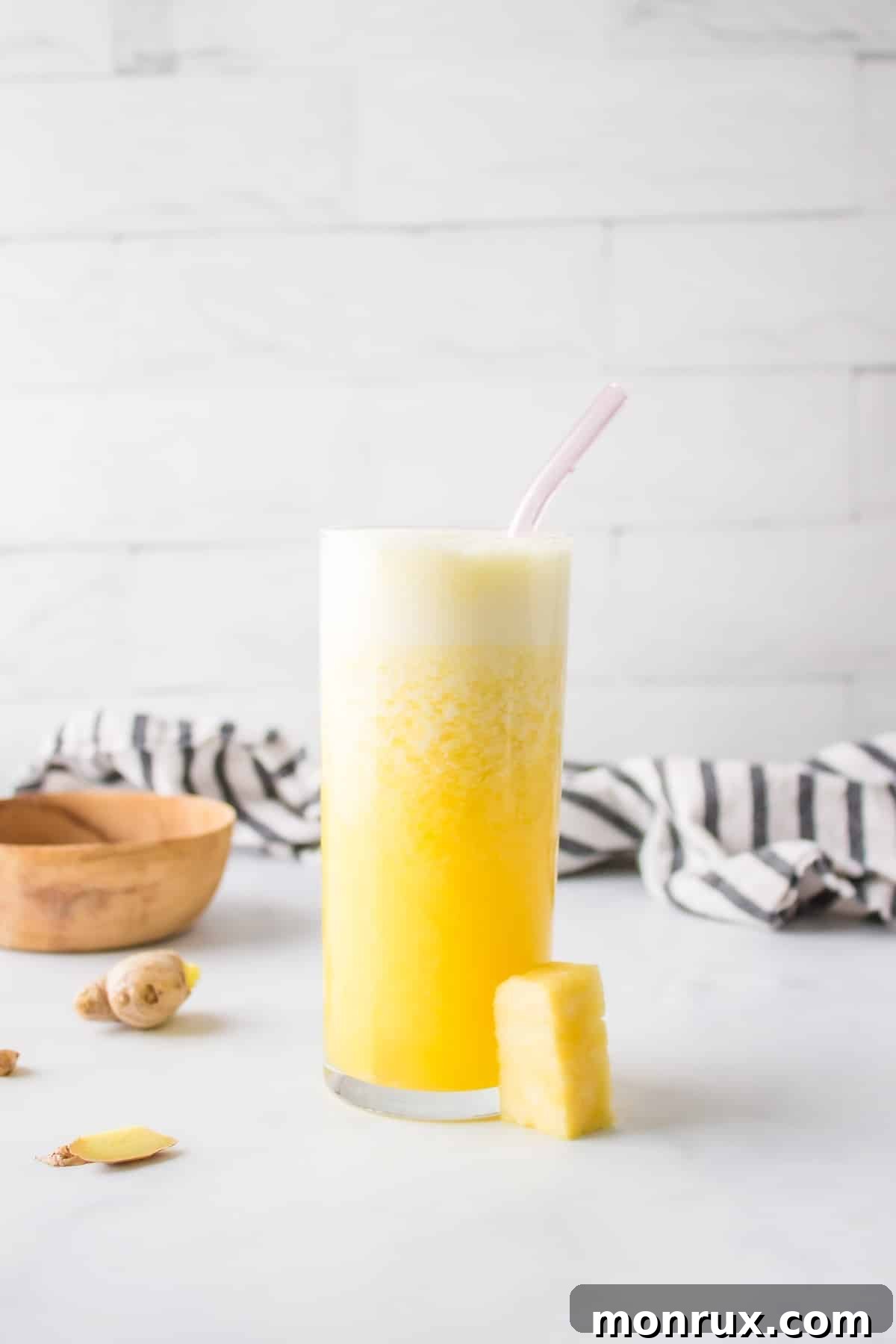 Freshly prepared Pineapple Ginger Juice with a straw, ready to drink.