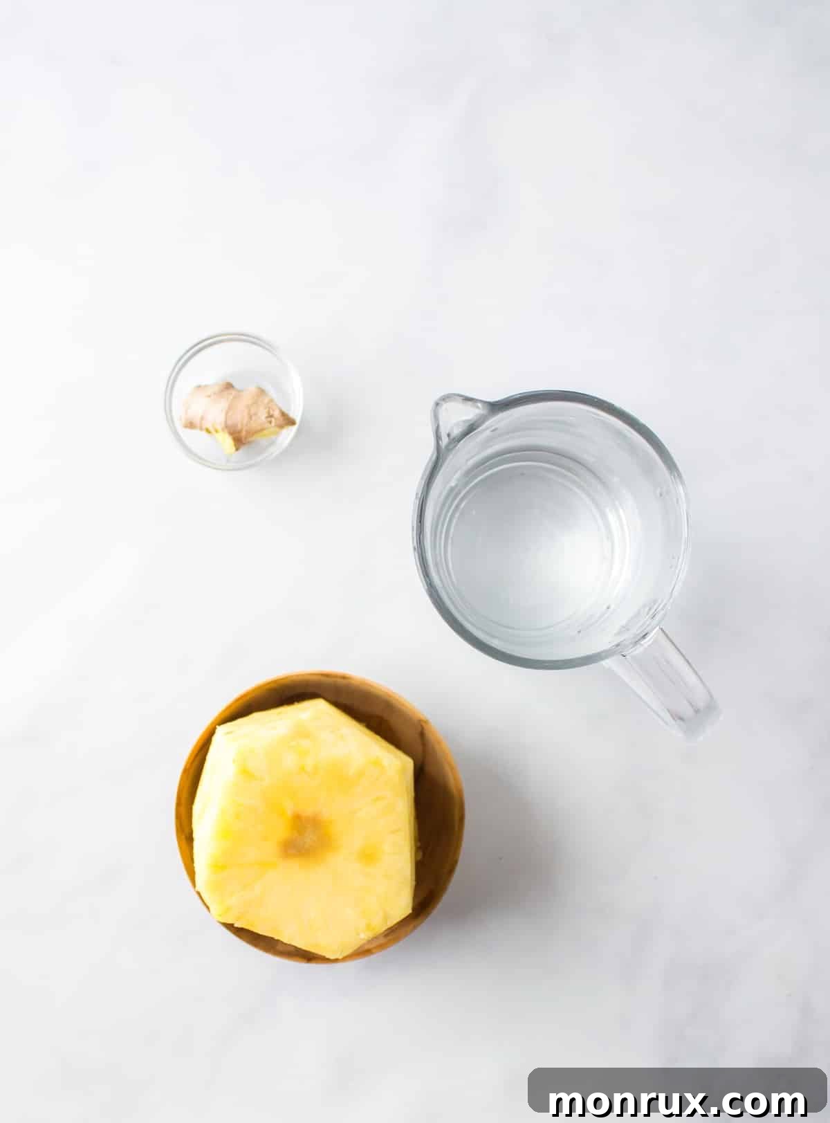Fresh pineapple and ginger root laid out on a table, ready for juicing.
