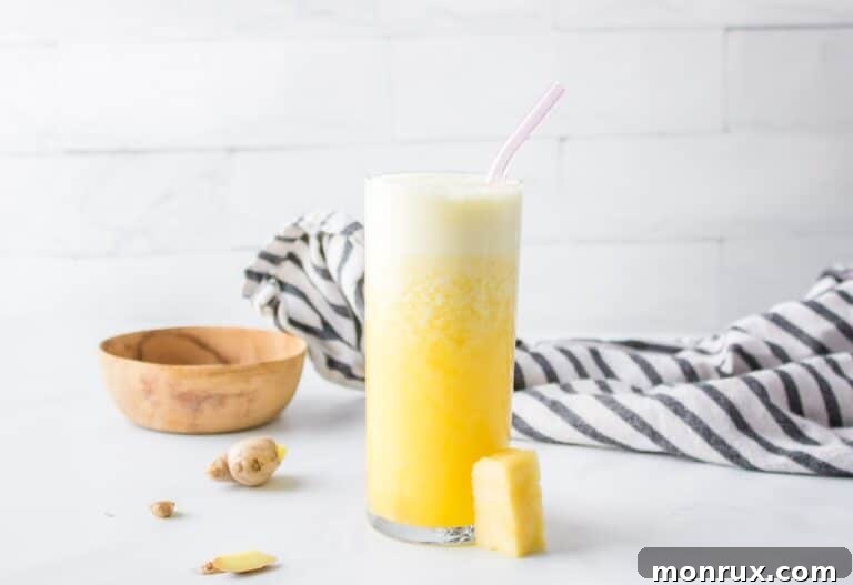 Pineapple Ginger Juice in a tall glass, garnished with a pineapple wedge.
