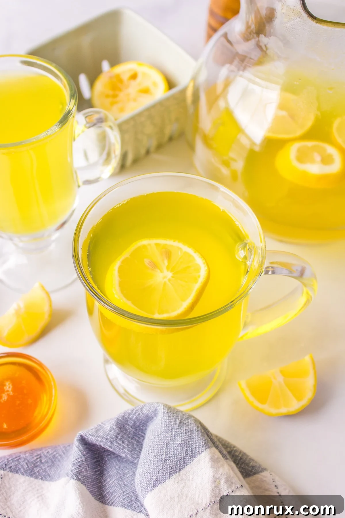 A warm mug of golden lemon ginger turmeric tea, garnished with lemon slices and ginger, radiating comfort.