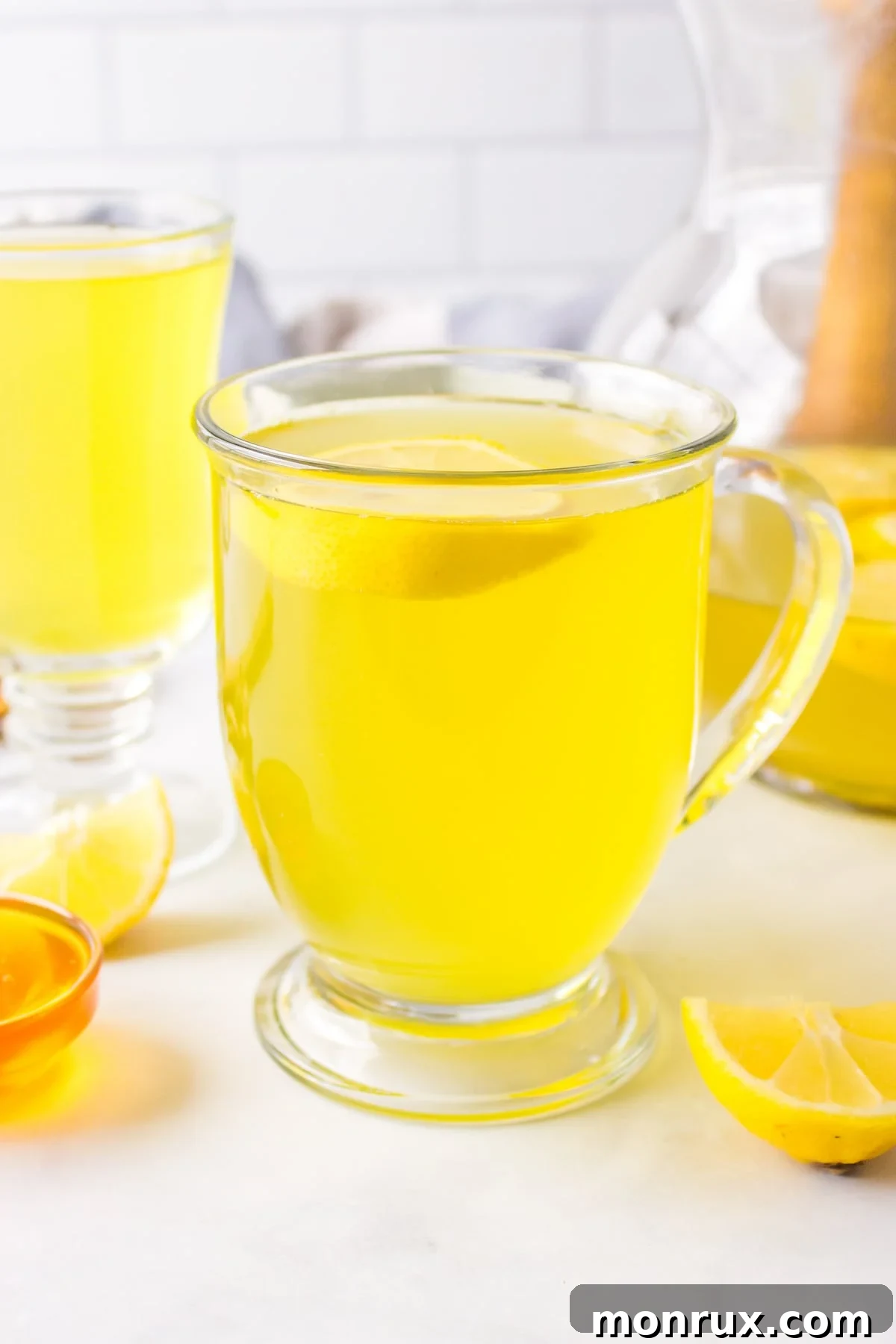 A beautiful front view of a steaming mug of golden lemon ginger turmeric tea, ready to be savored.