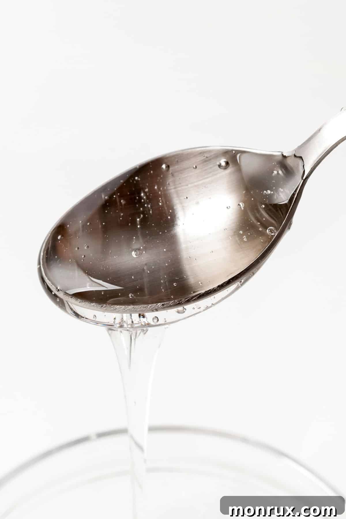 Malt syrup pouring out of a spoon.