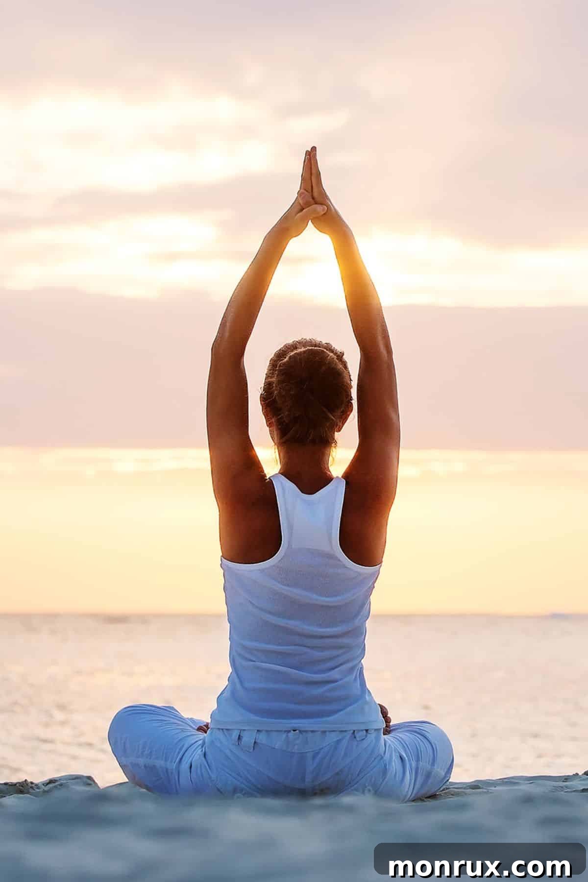 a woman in a yoga pose on the beach.