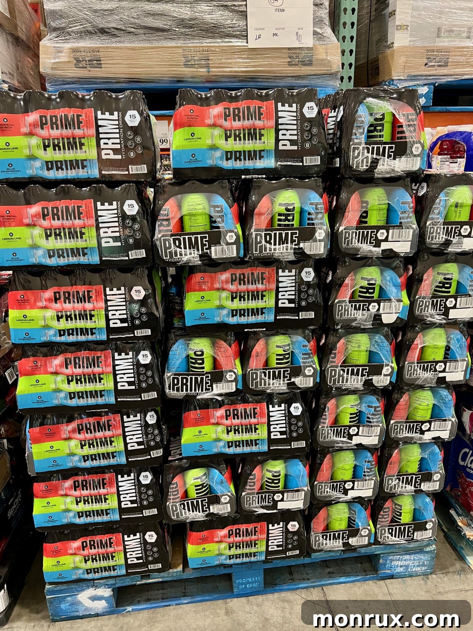Stacks of Prime Drink cases neatly arranged in a Costco store aisle, reflecting high demand and market presence.