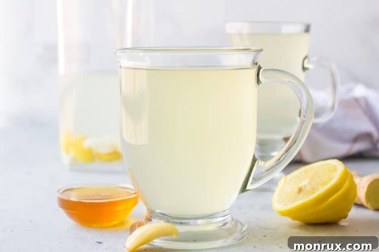 A glass of steaming garlic tea with lemon and ginger.