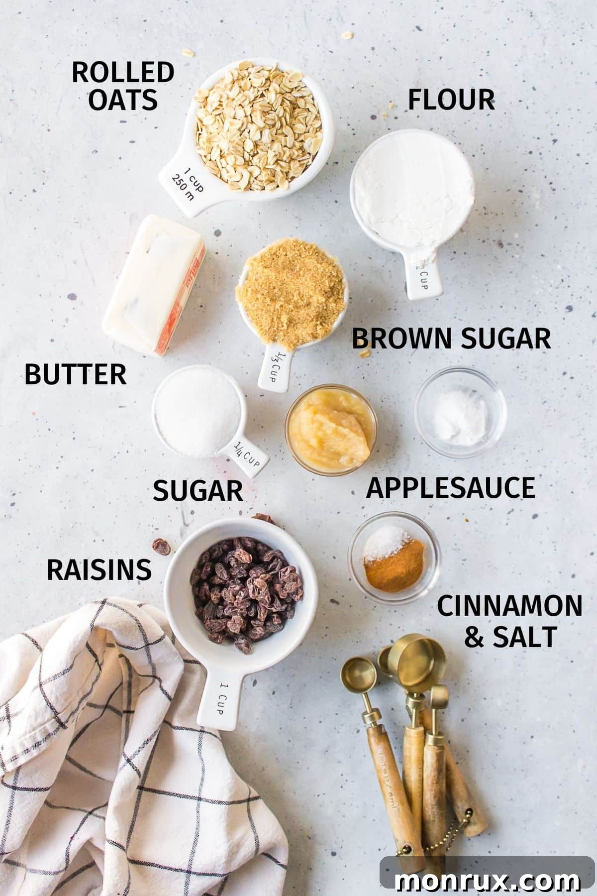 A flat lay of ingredients for making oatmeal cookies without eggs, including oats, flour, butter, and raisins.