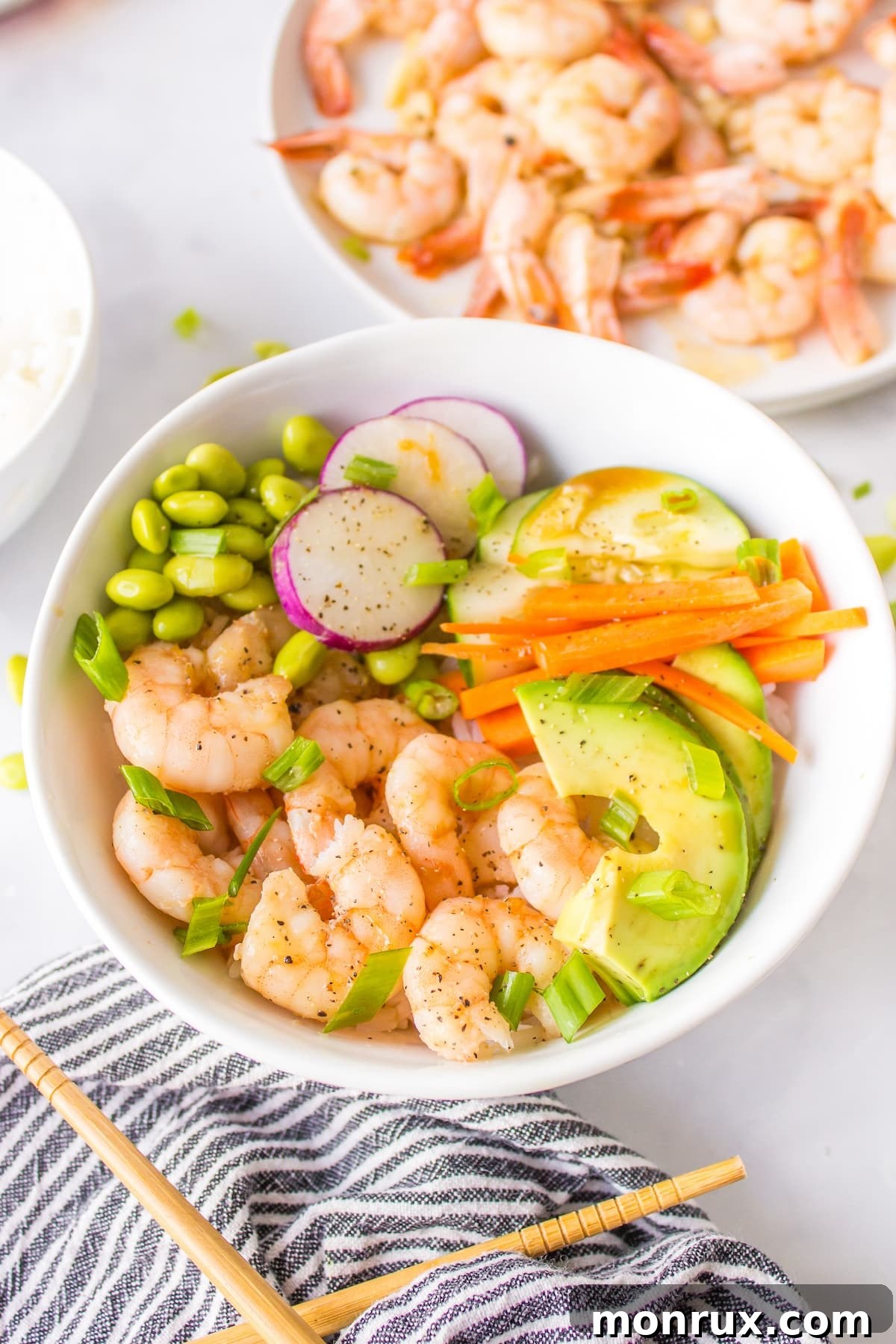 A vibrant and healthy shrimp poke bowl, featuring perfectly cooked shrimp, fresh vegetables, and rice.