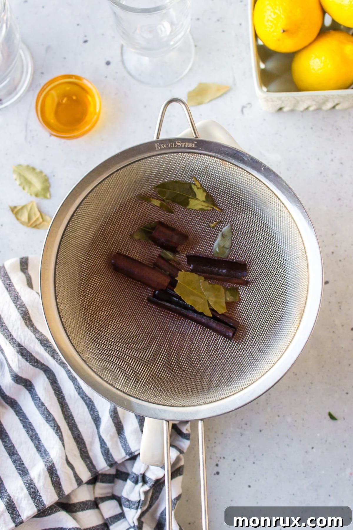 bay leaves and cinnamon sticks in a strainer.