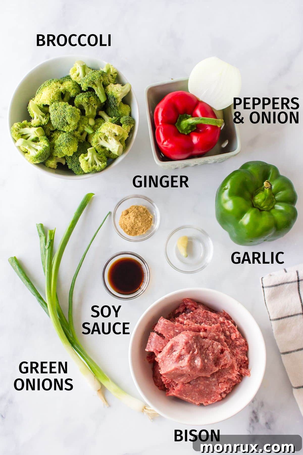 Fresh ingredients laid out for making a delicious bison stir-fry, including ground bison, bell peppers, broccoli, and ginger.