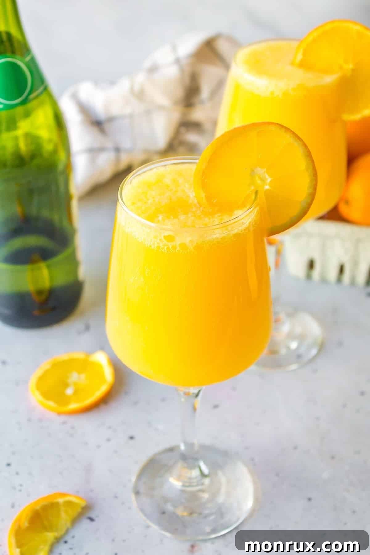 A beautifully presented glass of Mimosa Mocktail, garnished with an orange slice, radiating a vibrant, inviting glow.
